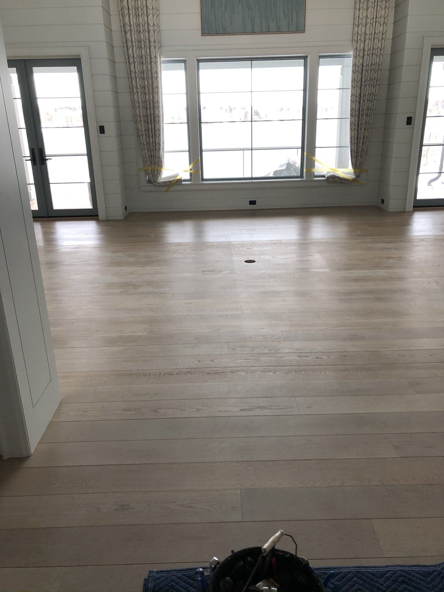 A large empty room with hardwood floors and a lot of windows.