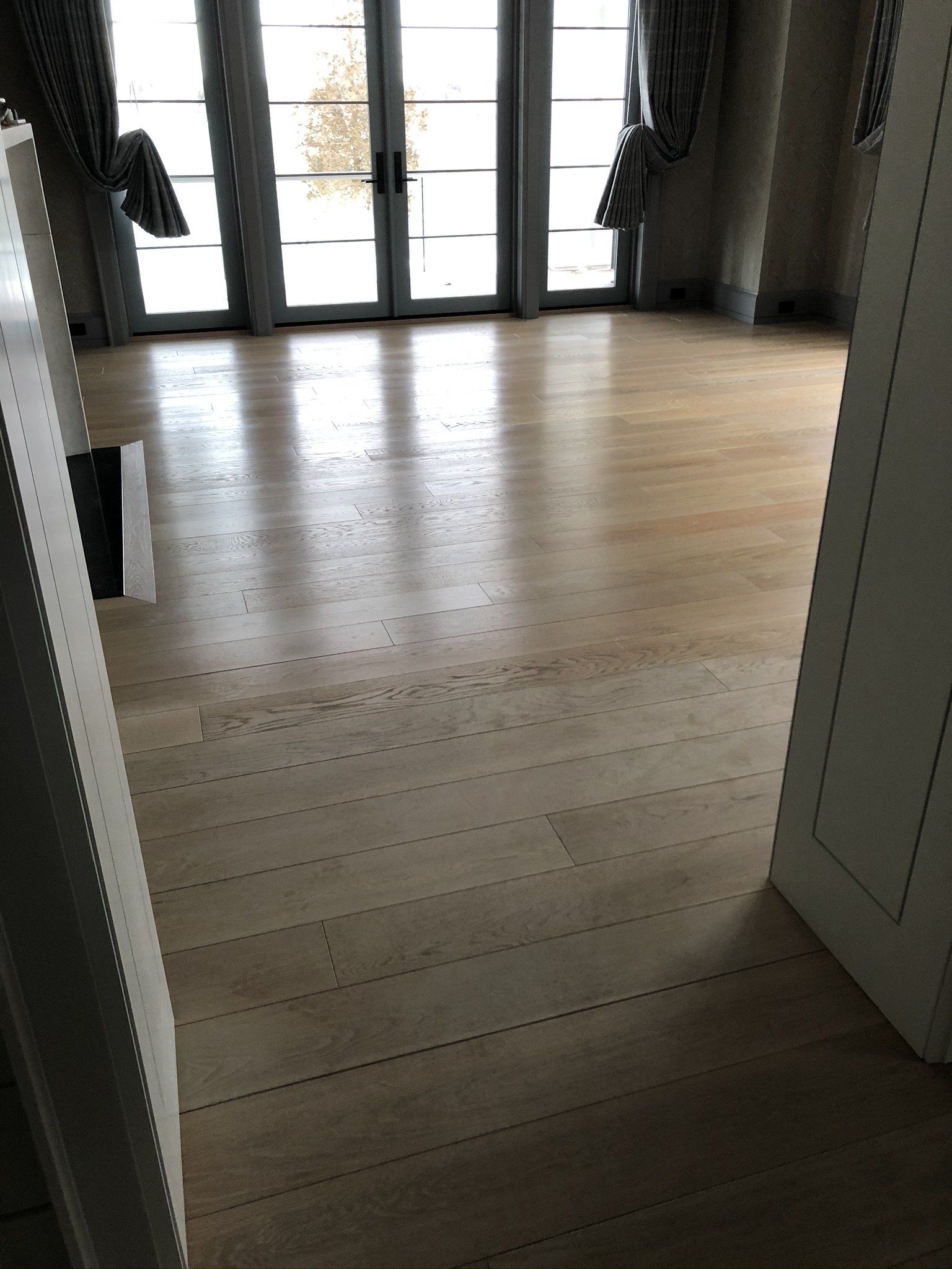 A room with a wooden floor and sliding glass doors