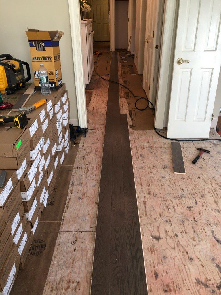 A long hallway with boxes and tools on the floor