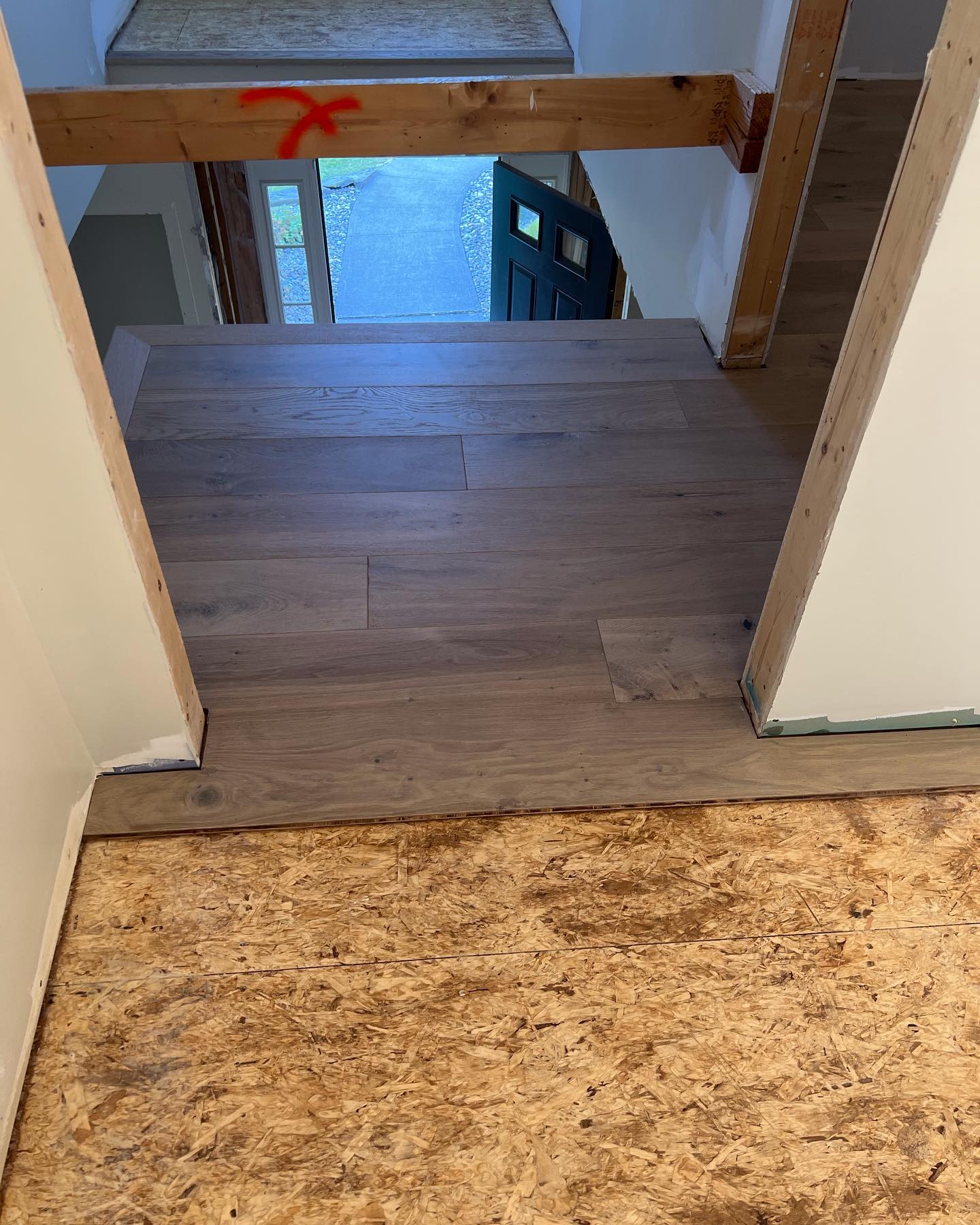 A wooden floor is being installed in a hallway.