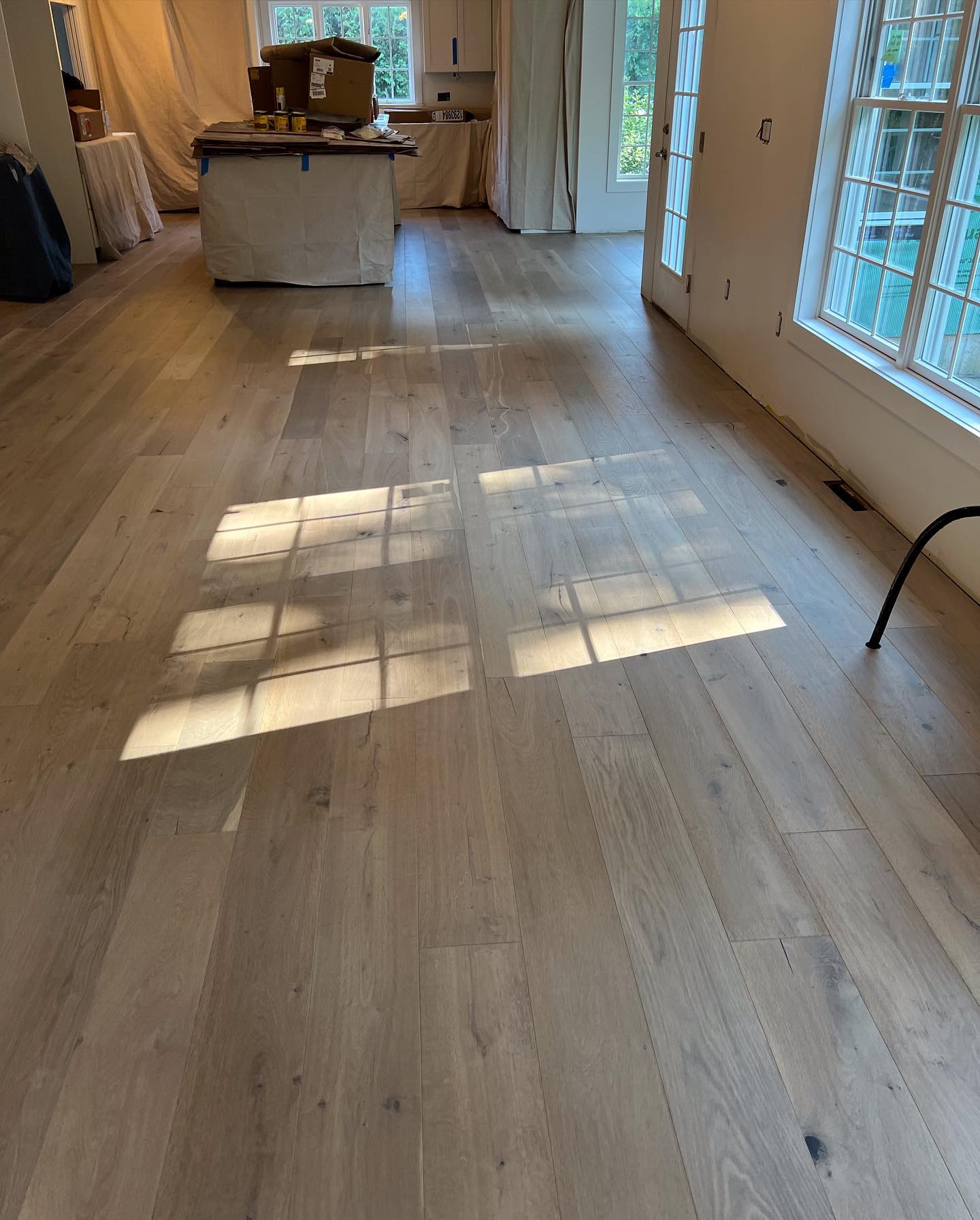 A room with hardwood floors and a large window.