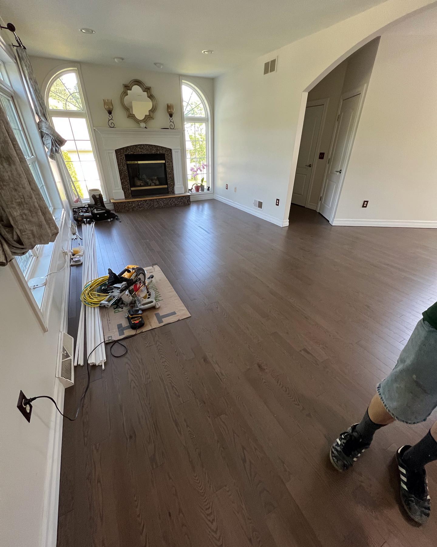 A living room with hardwood floors and a fireplace.