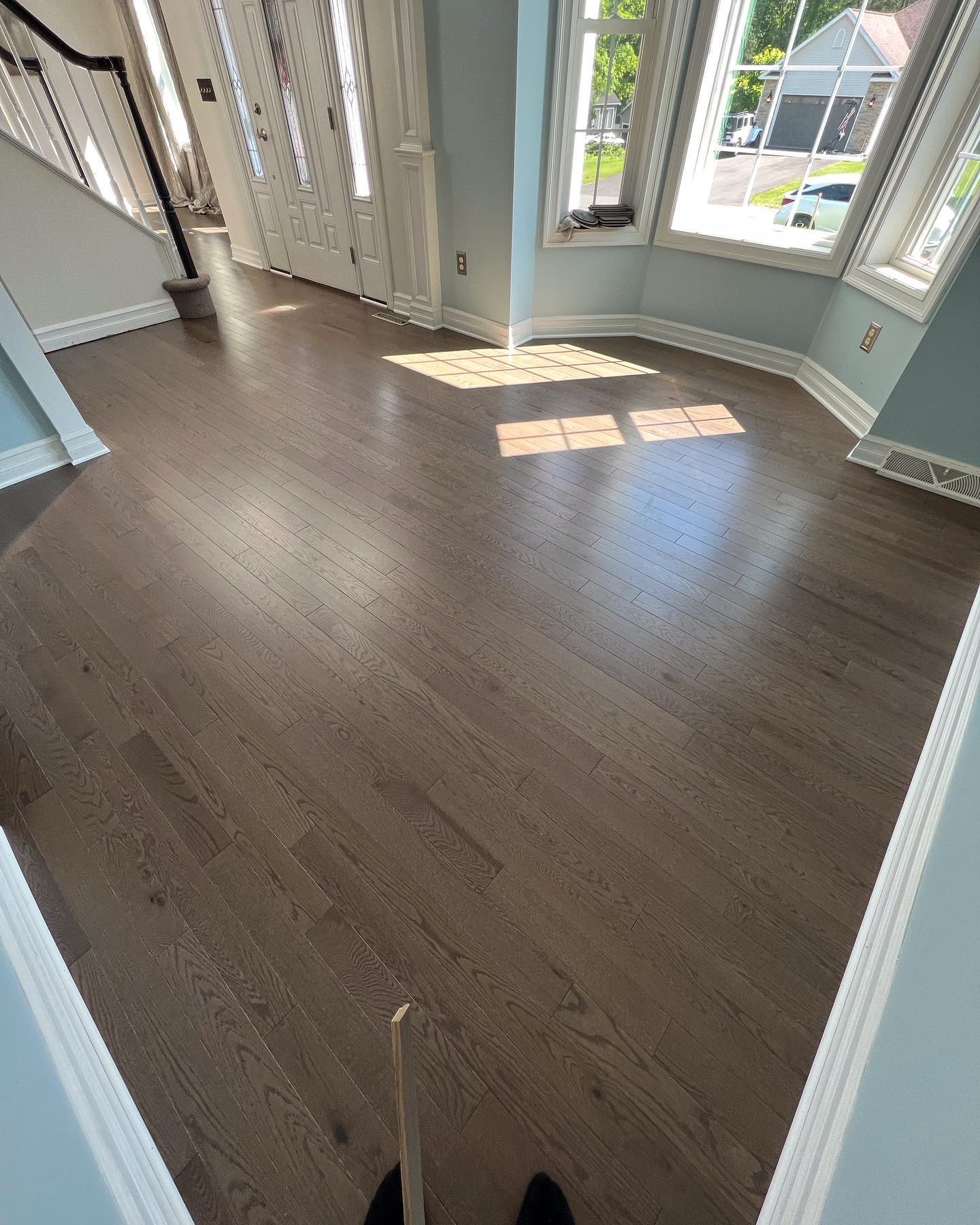 A person is standing on a wooden floor in a living room.