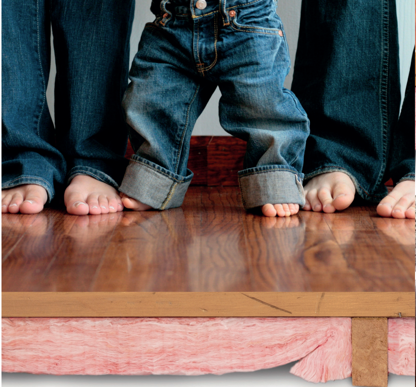 Three Sets Of Feet Standing On A Timber Floor Install Over Pink Batts Floor Insulation — Austral Insulation In Toormina, NSW
