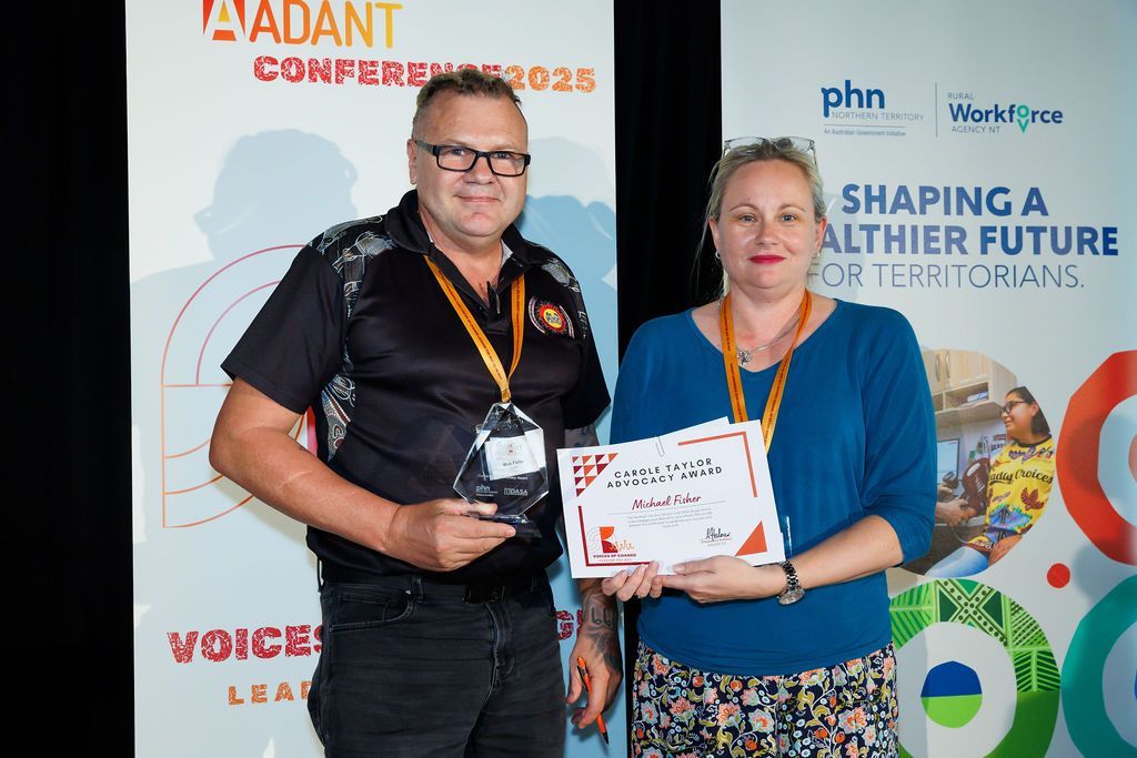 Two people stand together at the ADANT Conference 2025, one holding an award and the other holding a certificate.