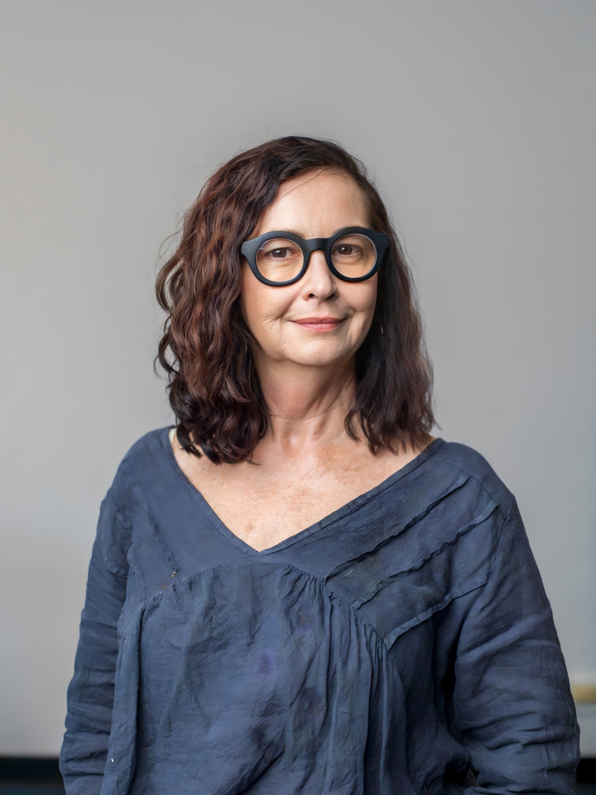 A young man is holding a yellow television in his hands.