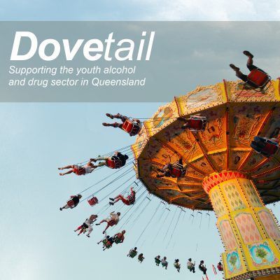 A swinging carnival ride with people in mid-air against a light sky, with a banner that reads 