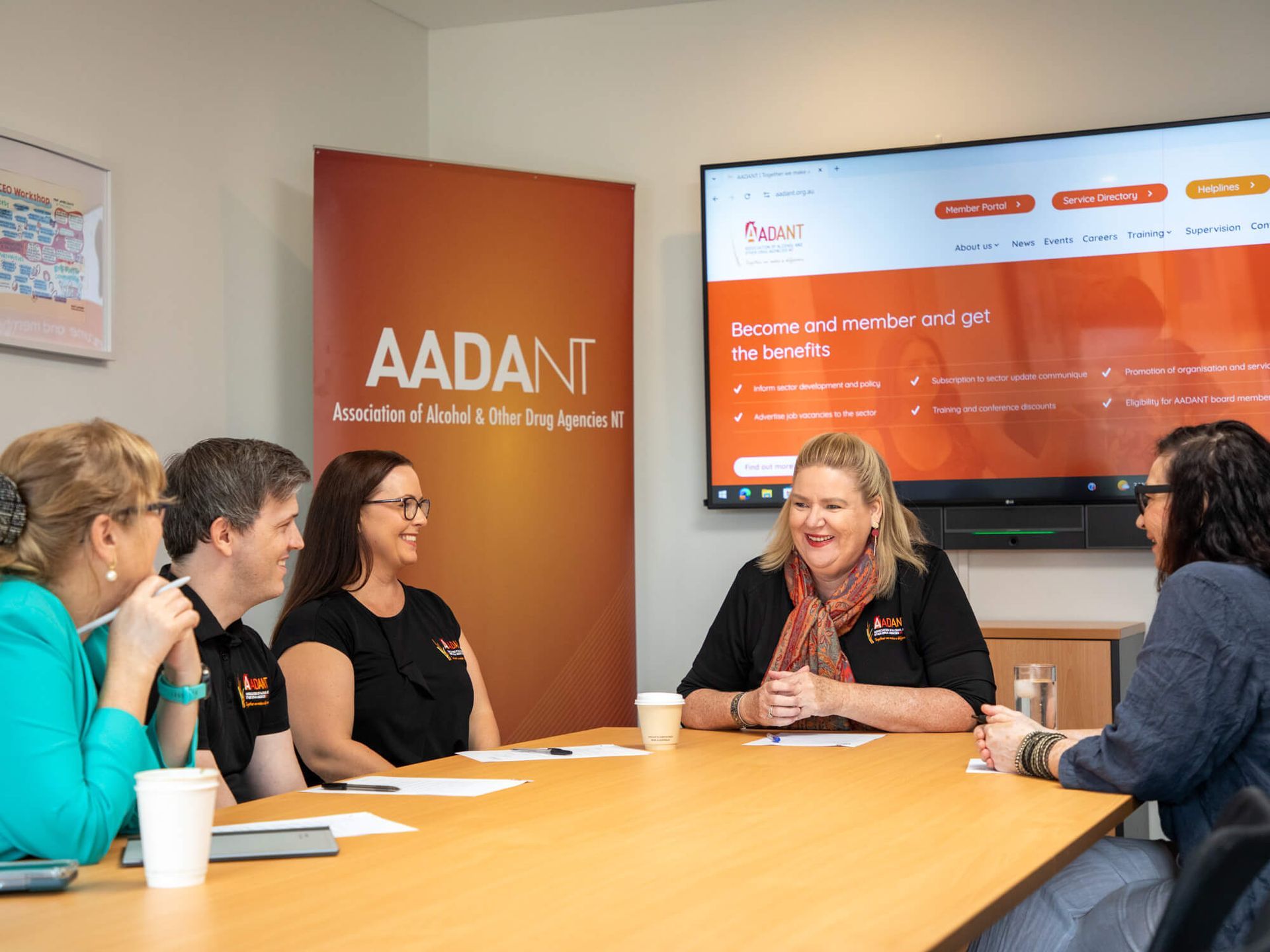 A group of people are sitting around a table in a conference room.