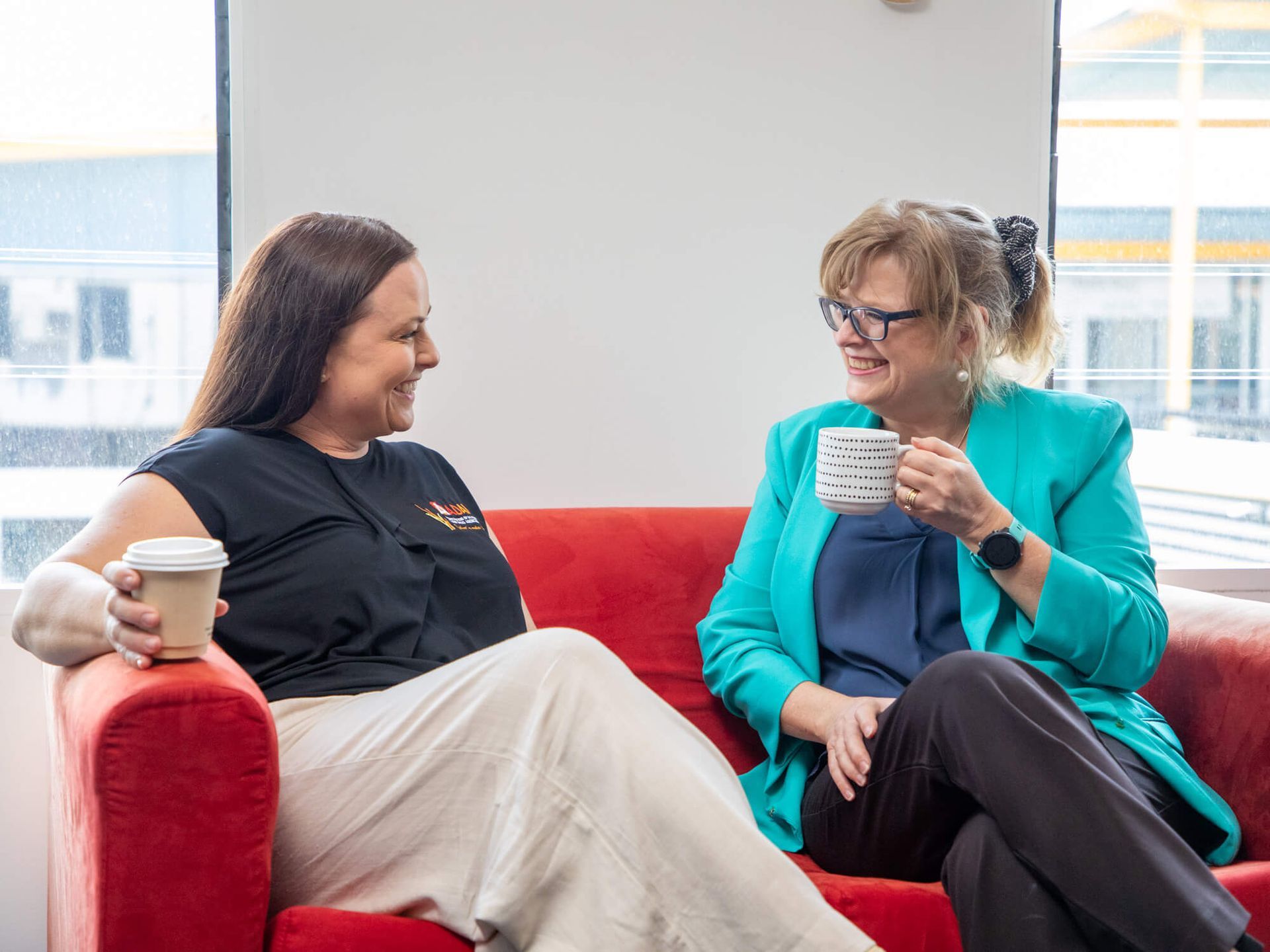 A group of people are sitting around a table talking to each other.