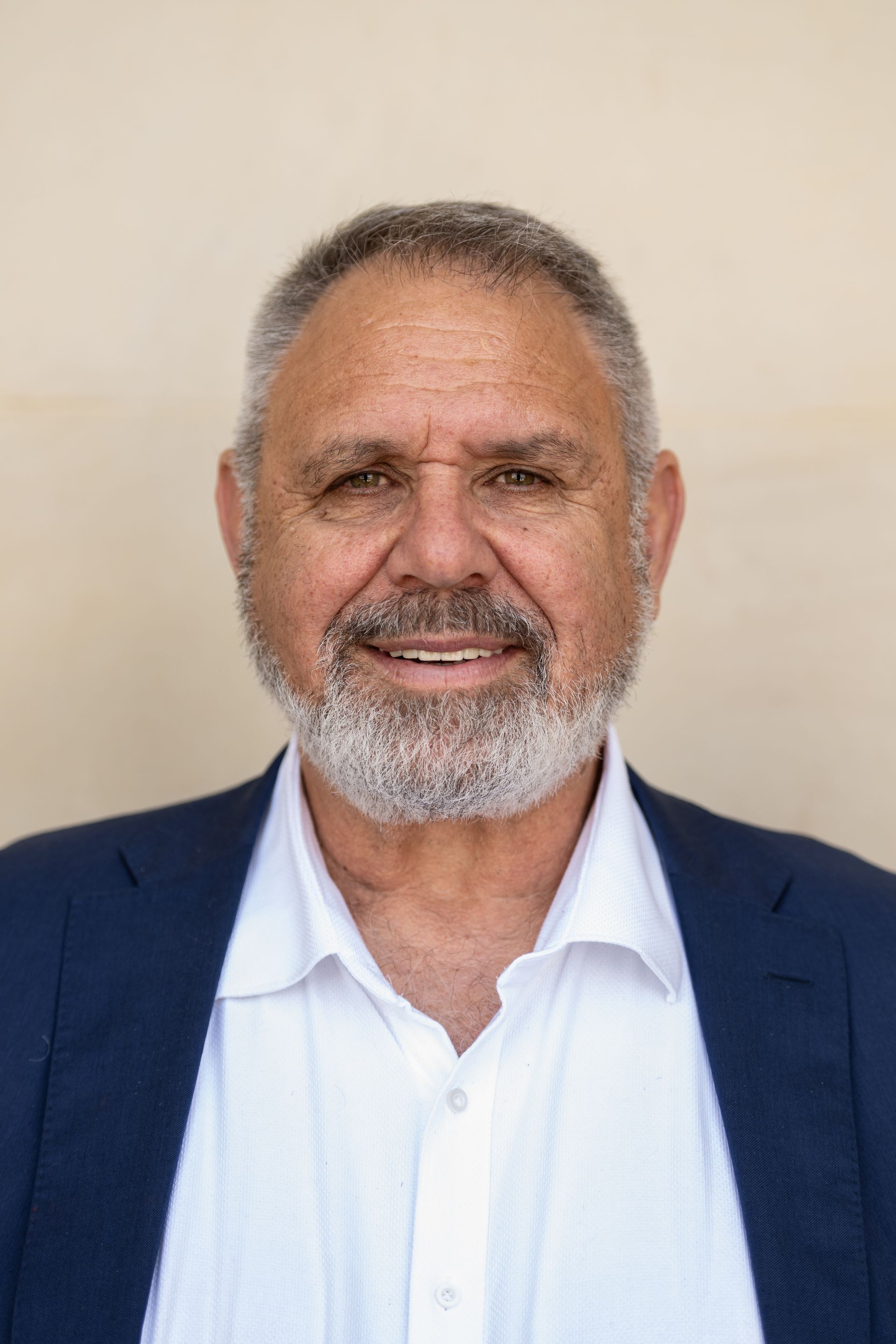 A man with a beard and a blue jacket is smiling for the camera.