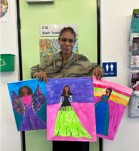 A woman is holding a painting of a woman in a dress