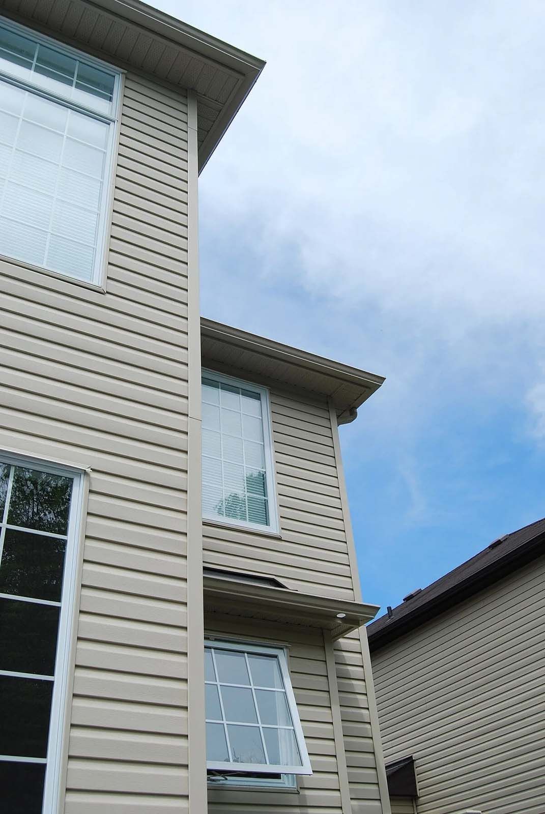 A house with a lot of windows and a blue sky in the background
