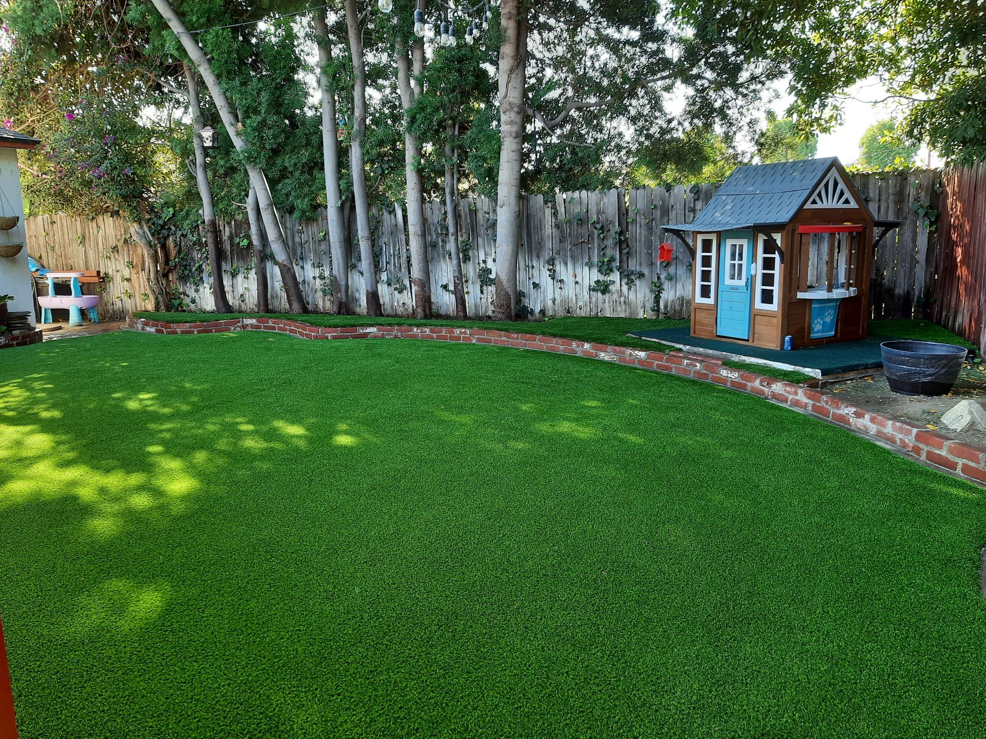 back yard planter with artificial grass and trees