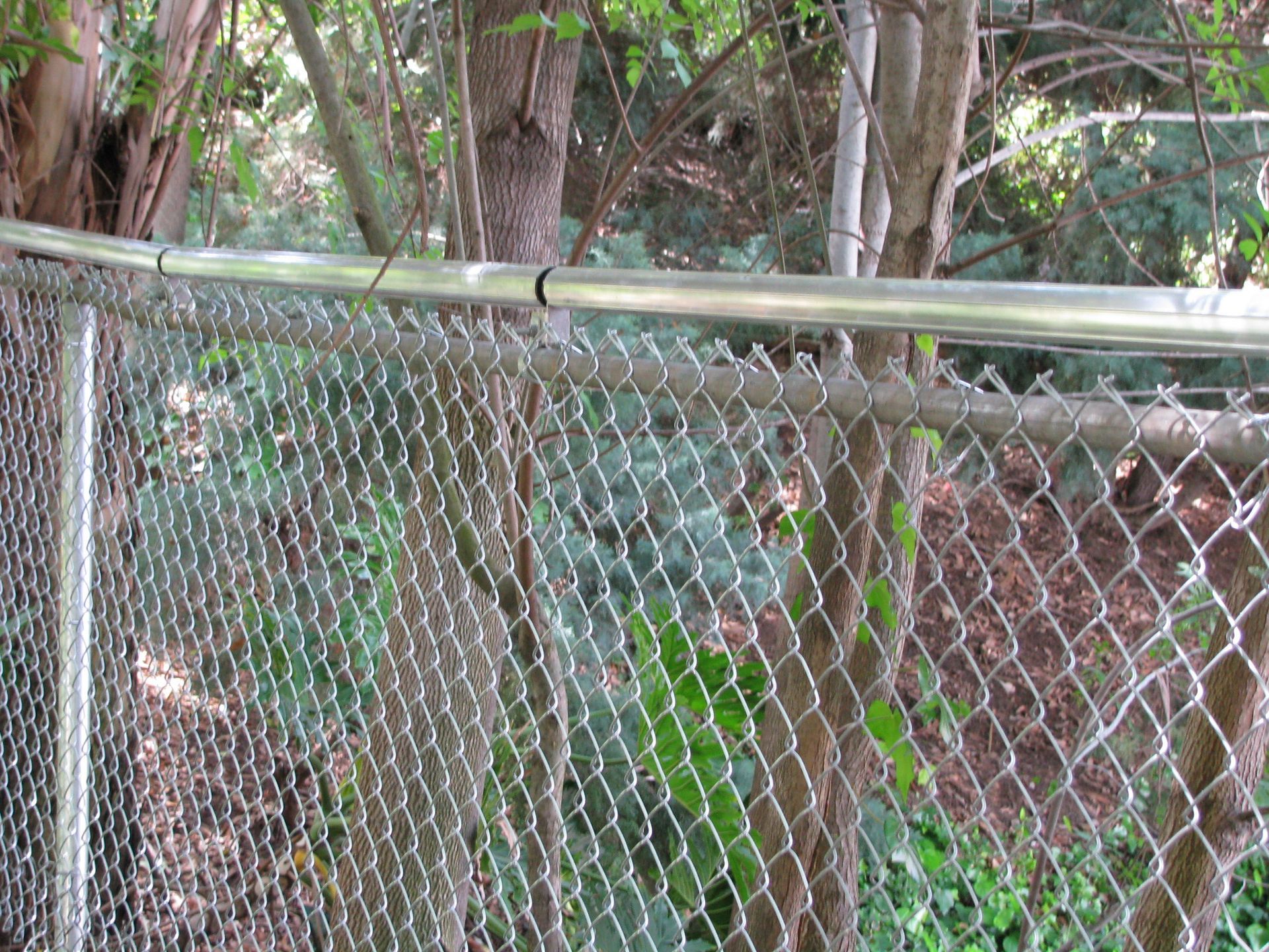 Coyote rollers on chain link fence.