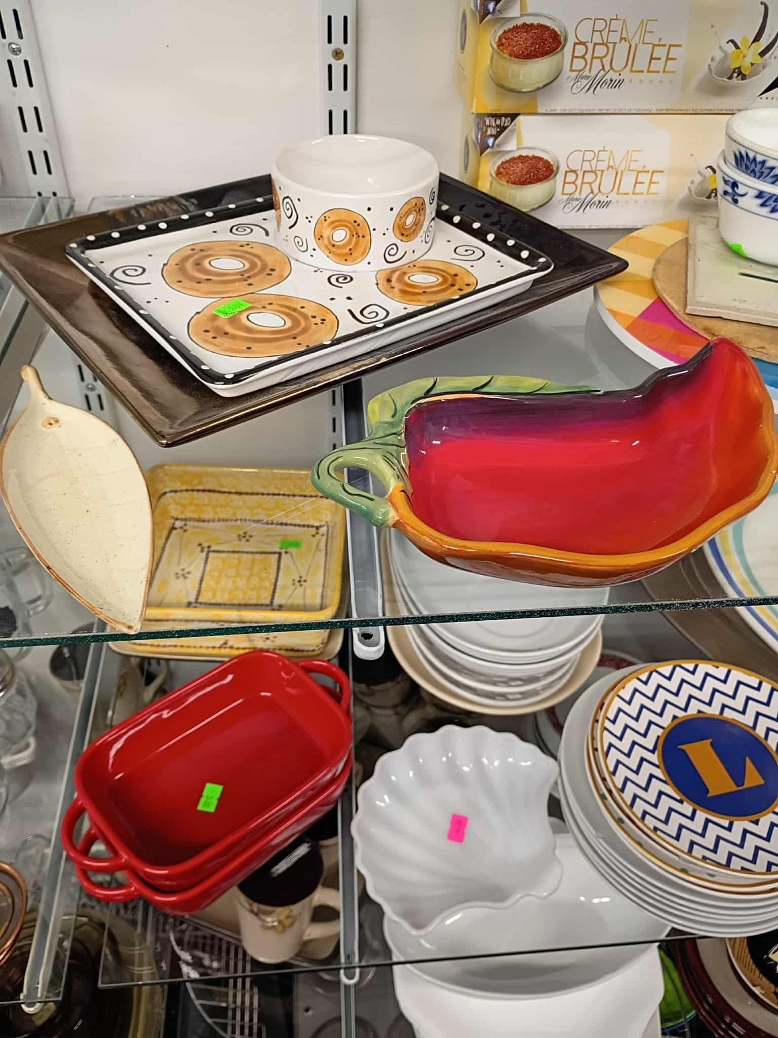Shelf of various dishes and serving pieces for sale at a store.
