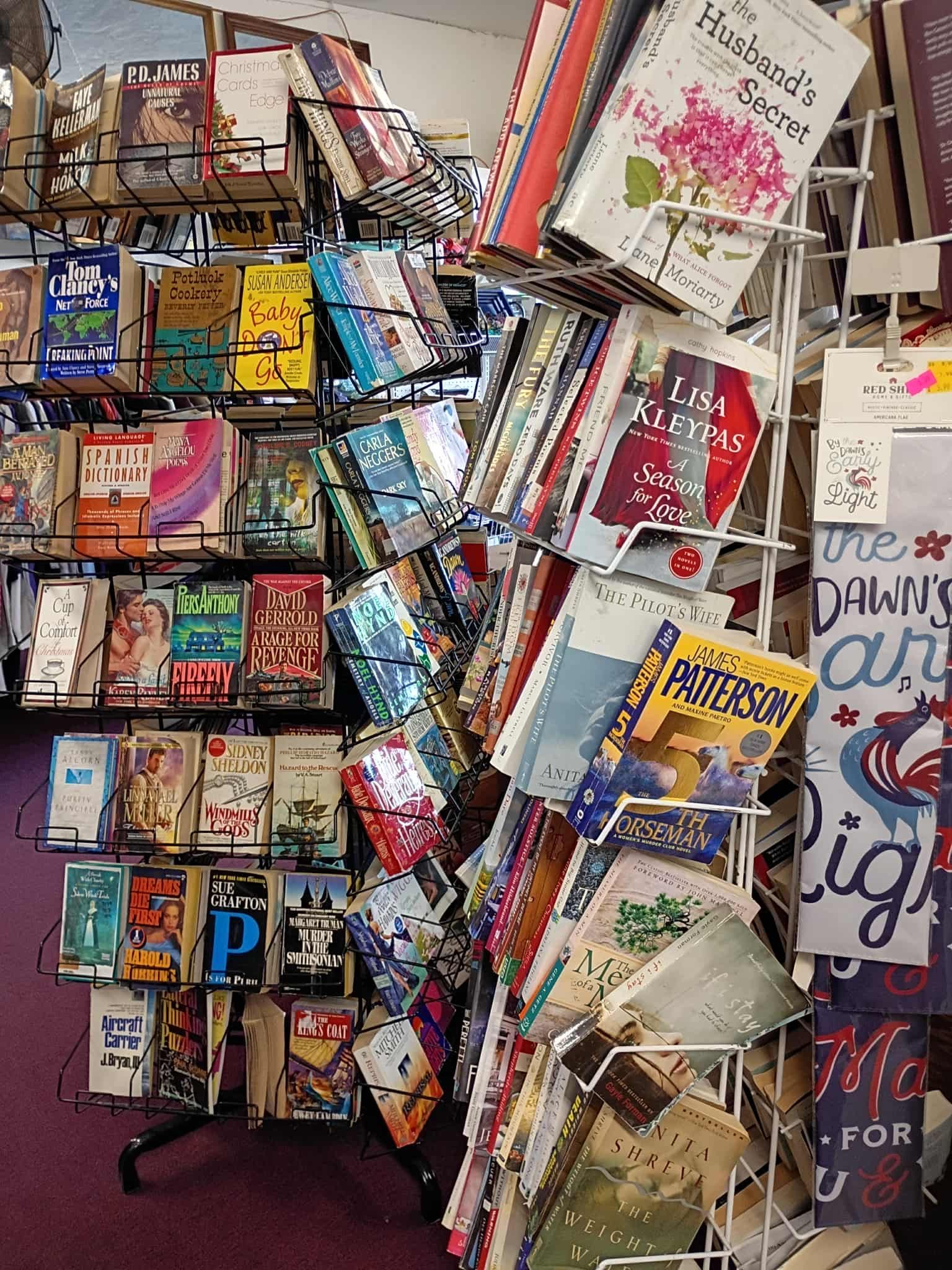 Books on metal shelves and a wire rack in a bookstore.