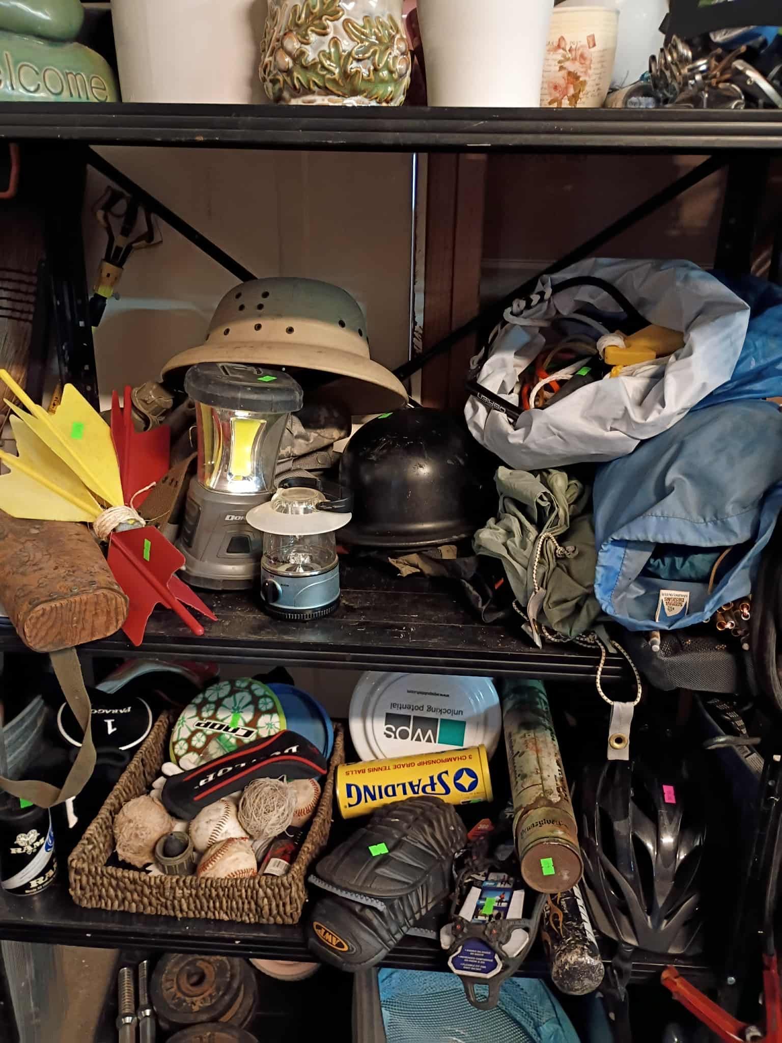 Shelf with various items: hats, lanterns, helmet, bags, and decor.