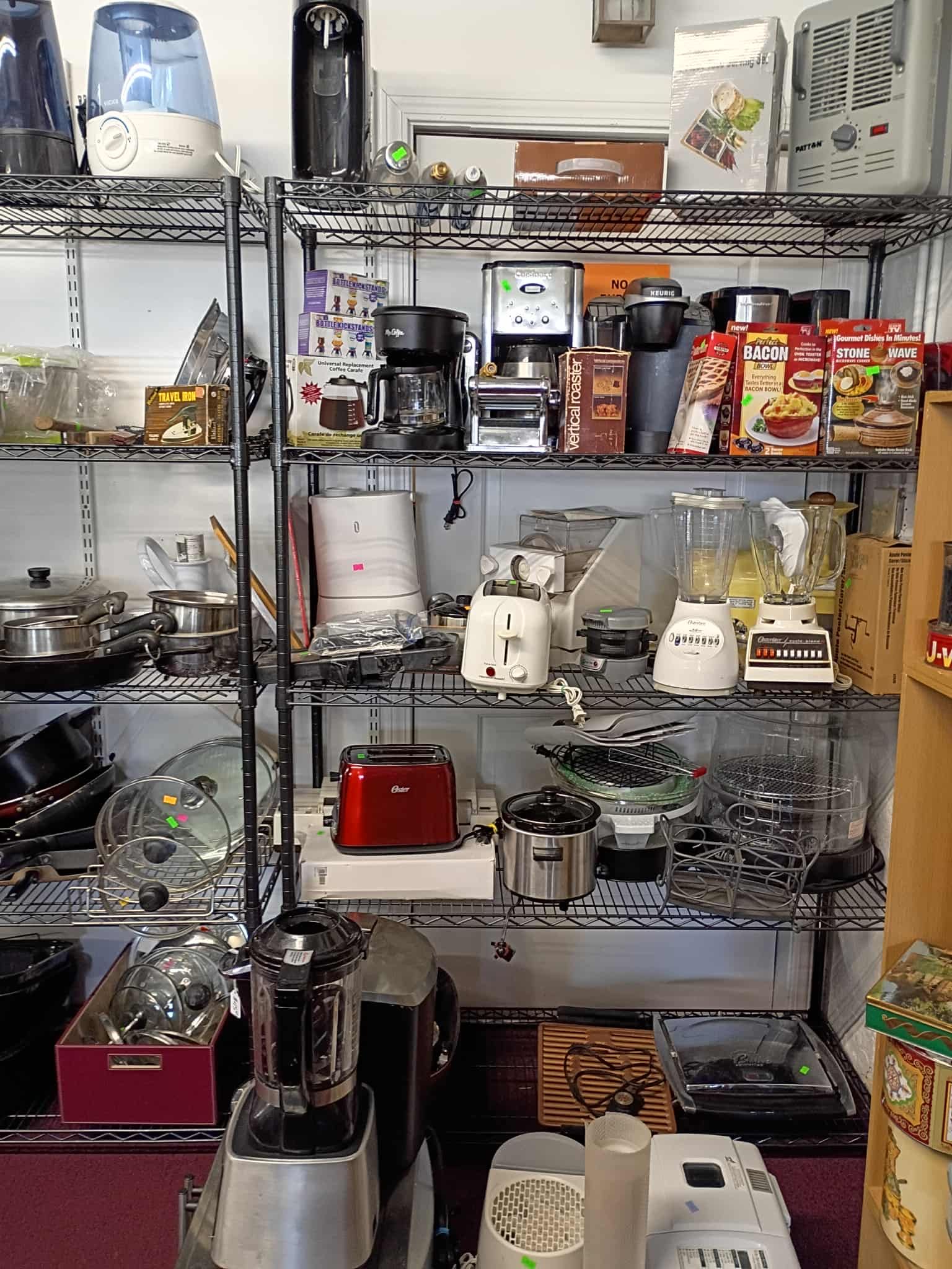 A store shelf filled with various kitchen appliances, including toasters, blenders, and coffee makers.