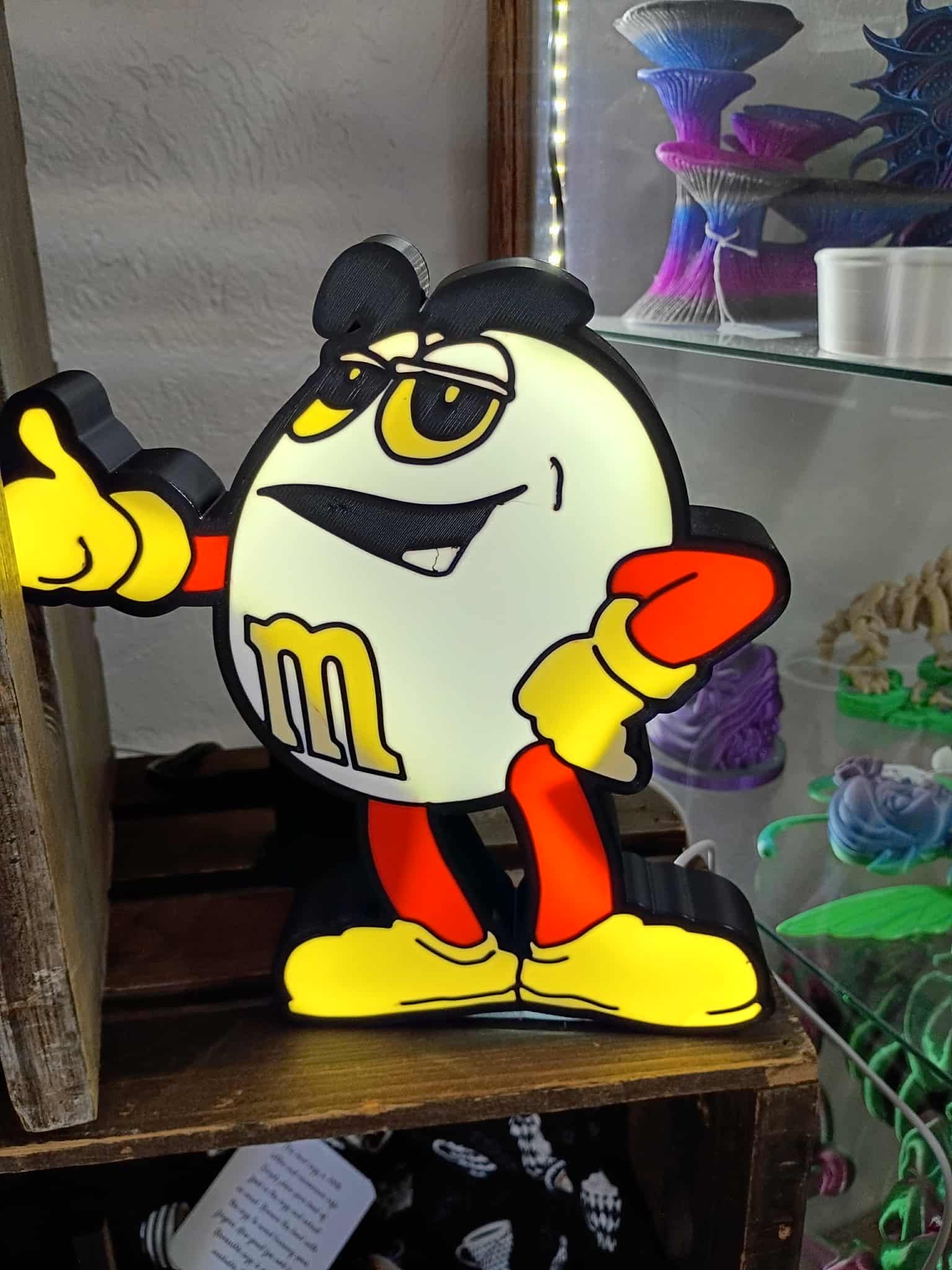Illuminated M&M's character lamp with yellow, red, and black accents