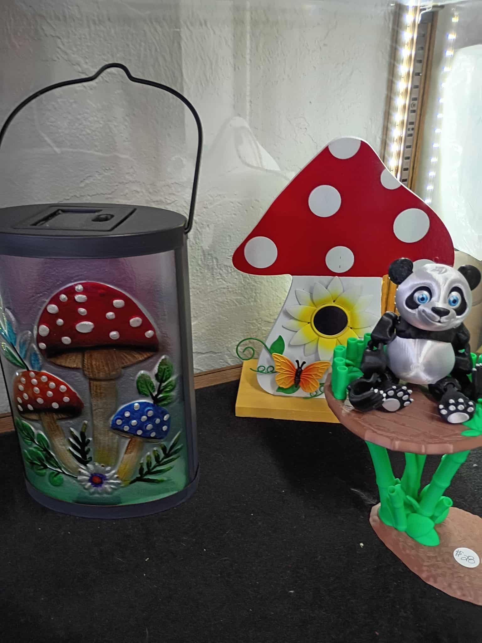 A whimsical display with mushroom-themed lantern, panda figurine, and a colorful mushroom-shaped decor.