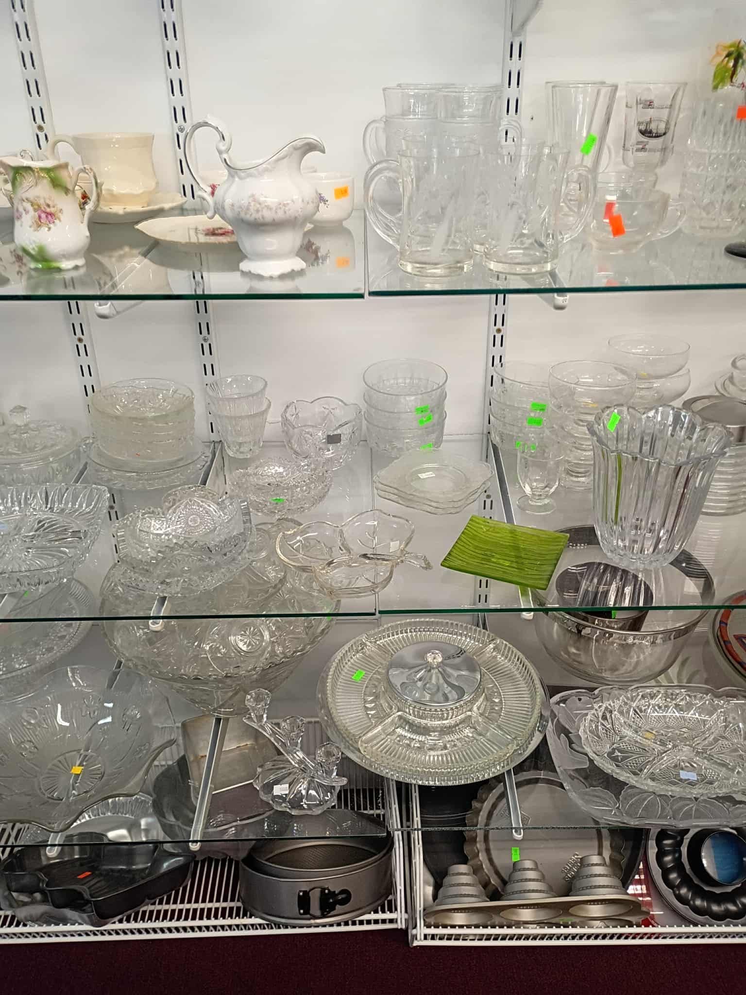 Glassware and dishware displayed in a lit cabinet at a store.