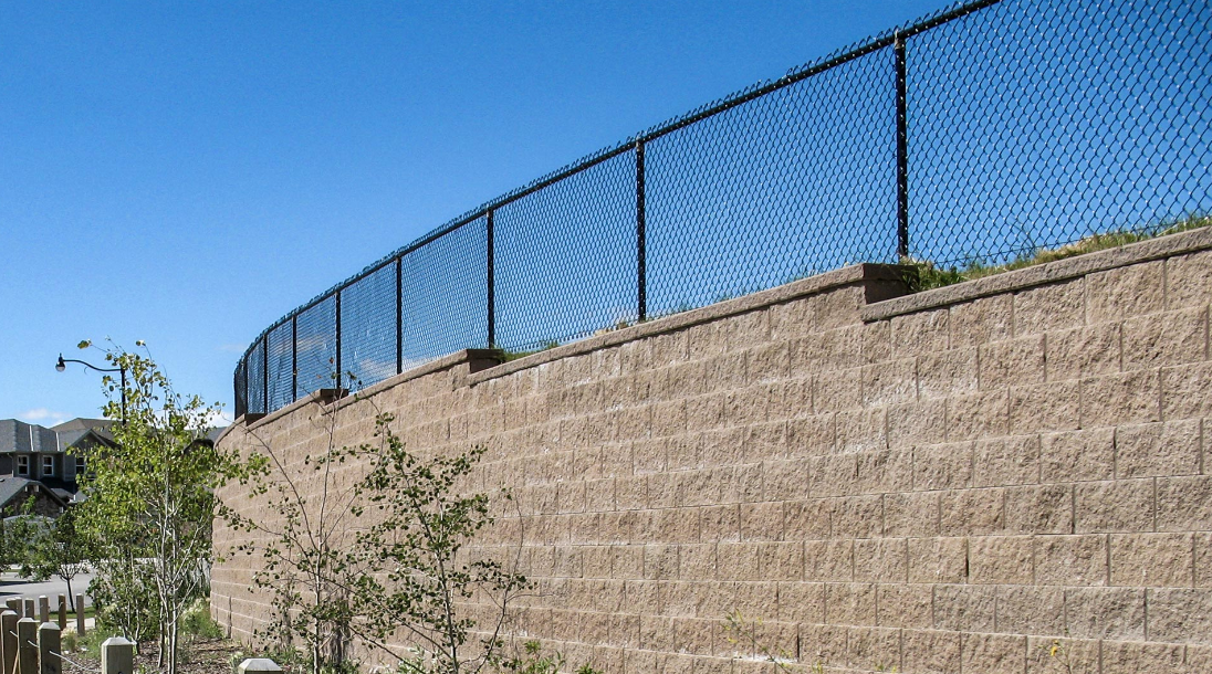 a retaining wall with a fence on top for safety