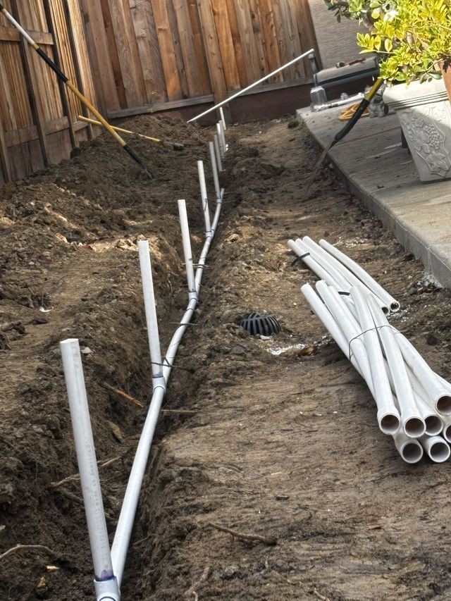 Bearded person installing a light fixture on a white ceiling.