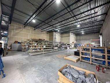 Modern living room with grey sofa, patterned rug, white walls, and pink curtains.