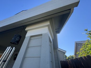 Man installing a window, standing inside a room with light gray walls.