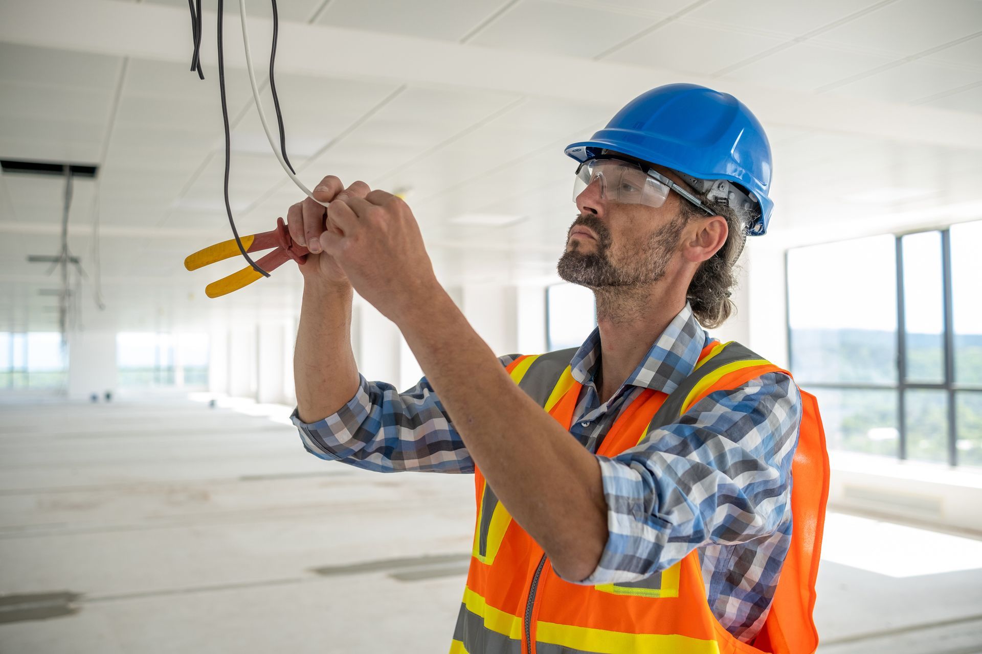 Electrician preparing the cables for the installation of lighting fixtures.