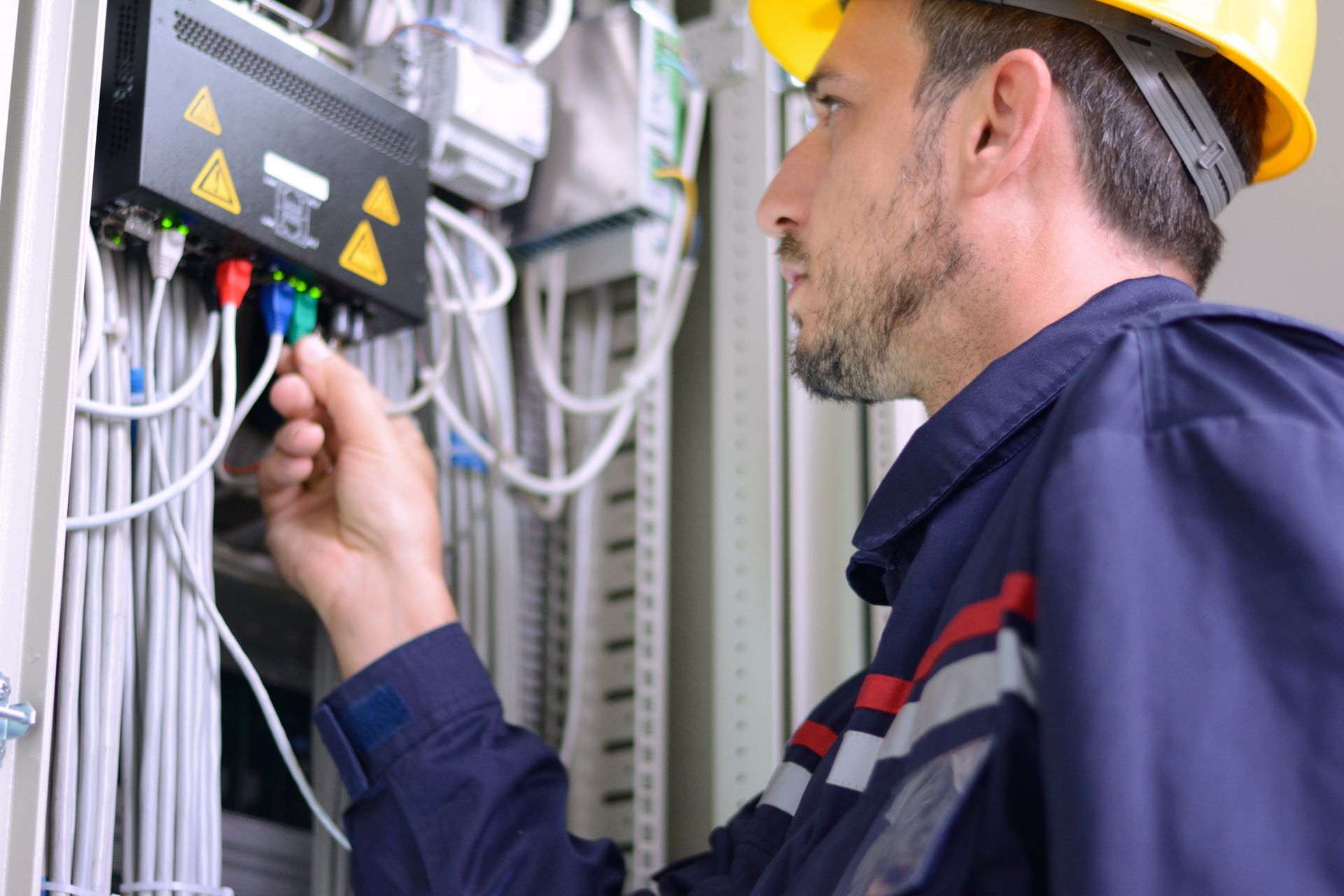 Technician connecting network cables in a server room.