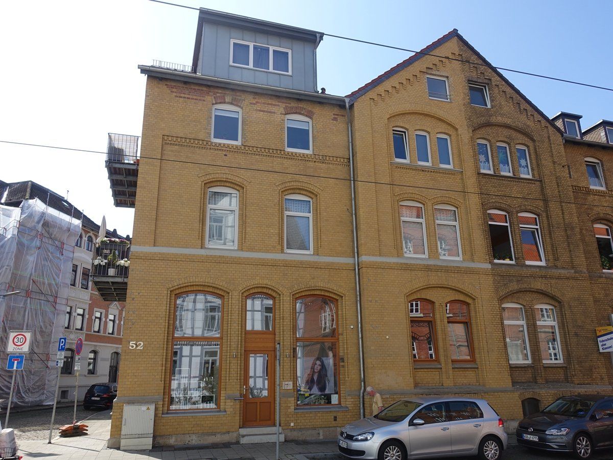 Ein Gebäude mit vielen Fenstern und einem davor geparkten Auto