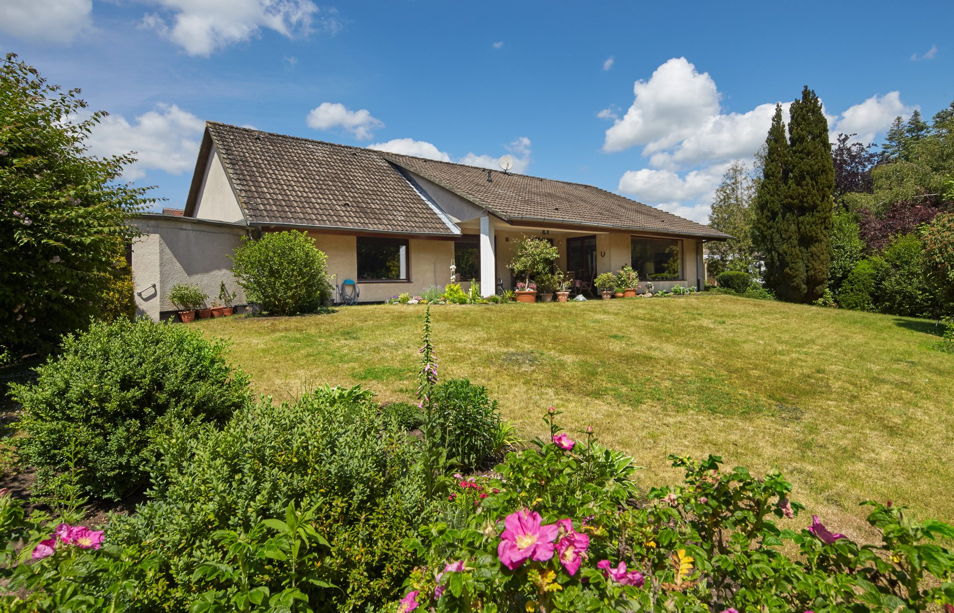 Ein Haus mit einem großen Rasen und Blumen davor