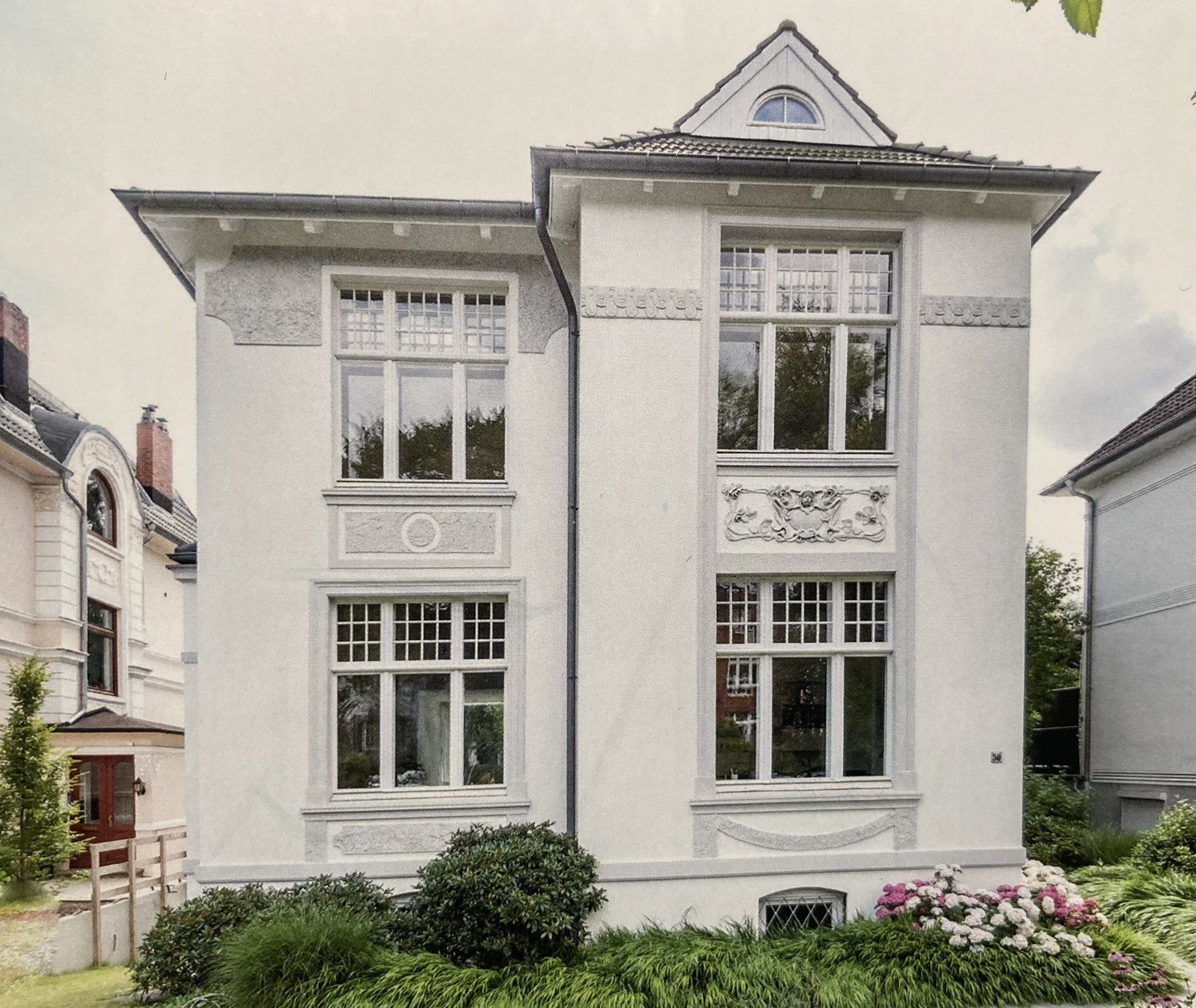 Ein großes weißes Haus mit einem pyramidenförmigen Dach