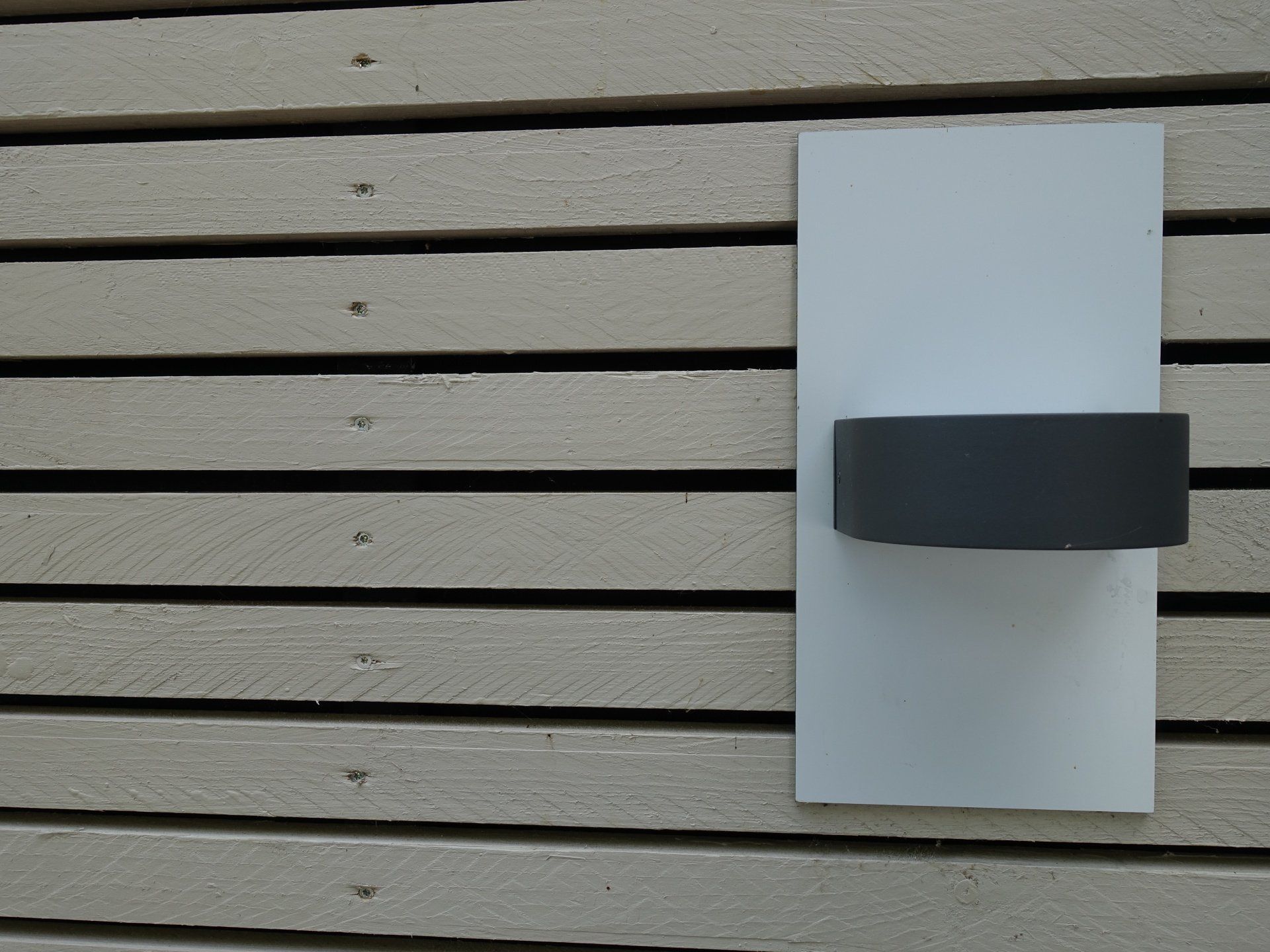 Eine Holzwand mit einem weißen Blatt Papier darauf