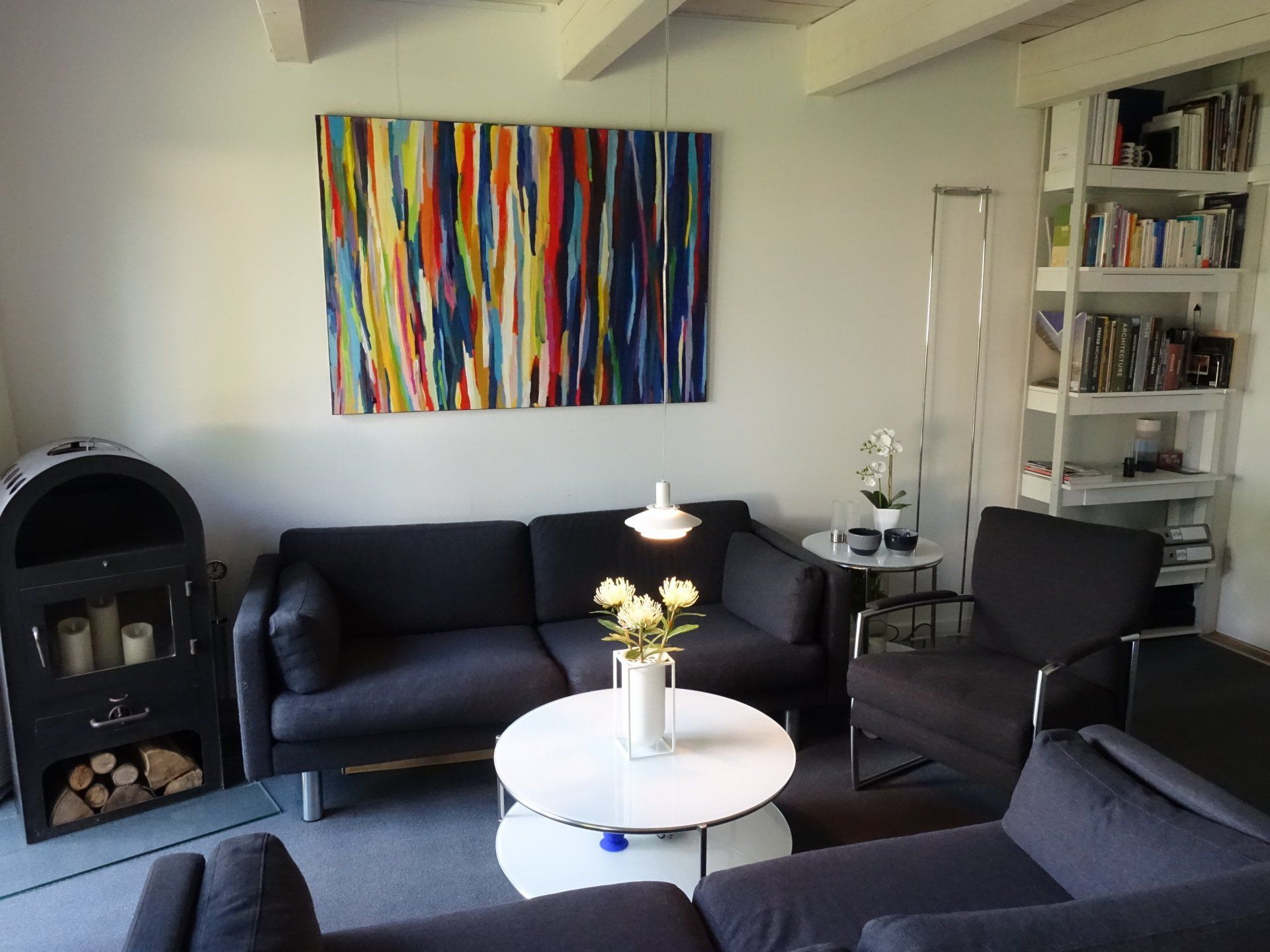 Ein Wohnzimmer mit einem bunten Gemälde an der Wand über der Couch