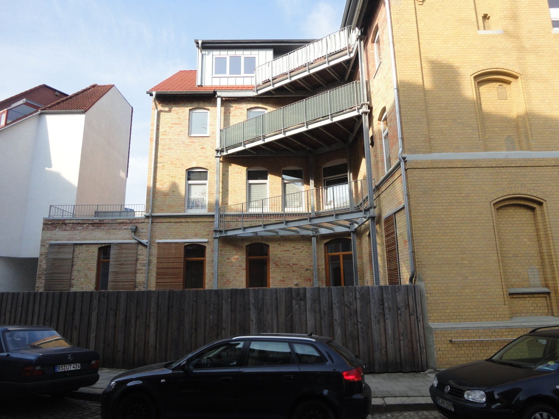 Ein schwarzes Auto steht vor einem Backsteingebäude