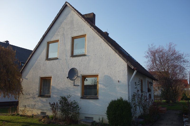 Ein weißes Haus mit einer Satellitenschüssel an der Seite