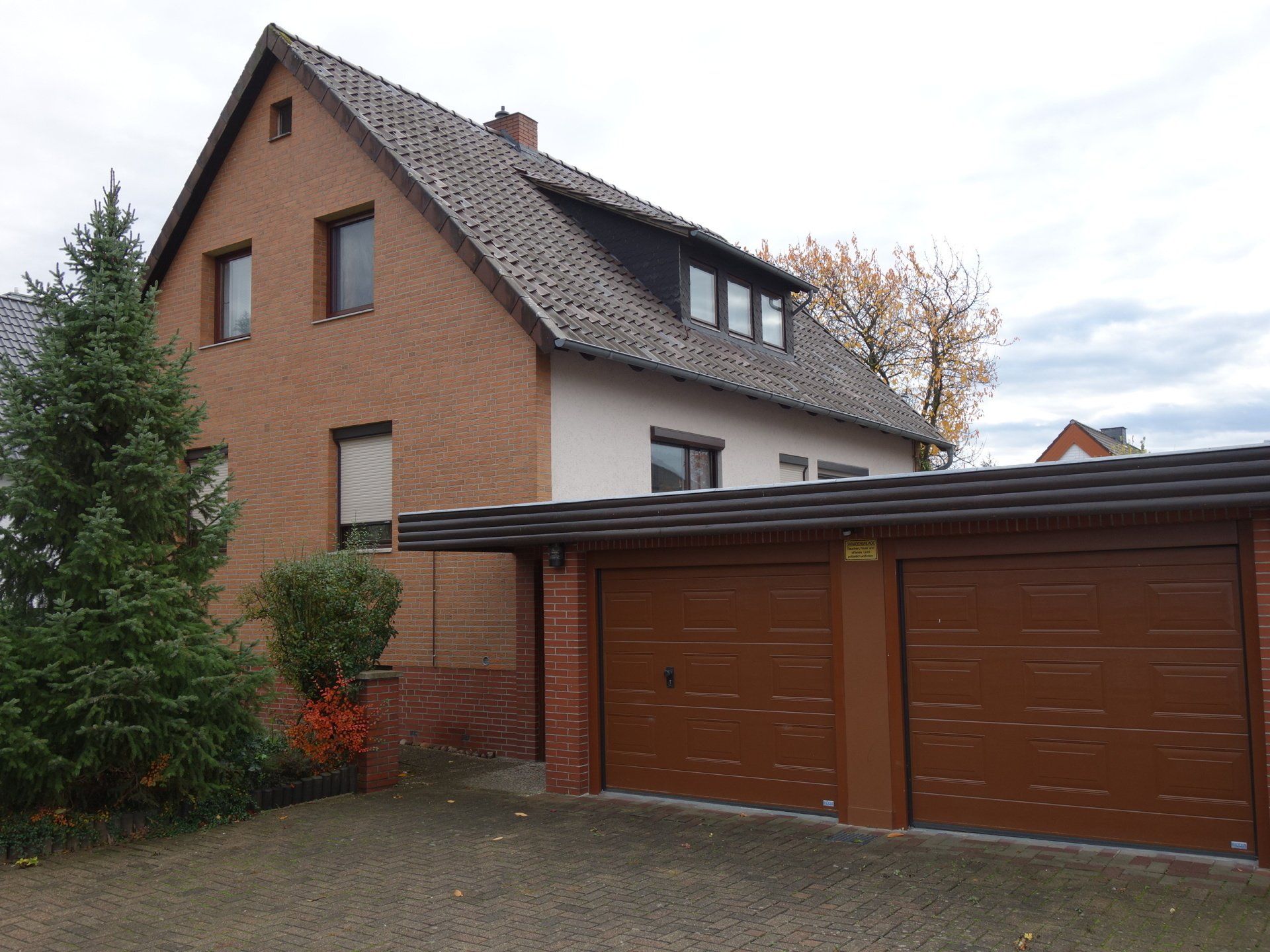 Ein großes Backsteinhaus mit einer Garage darunter