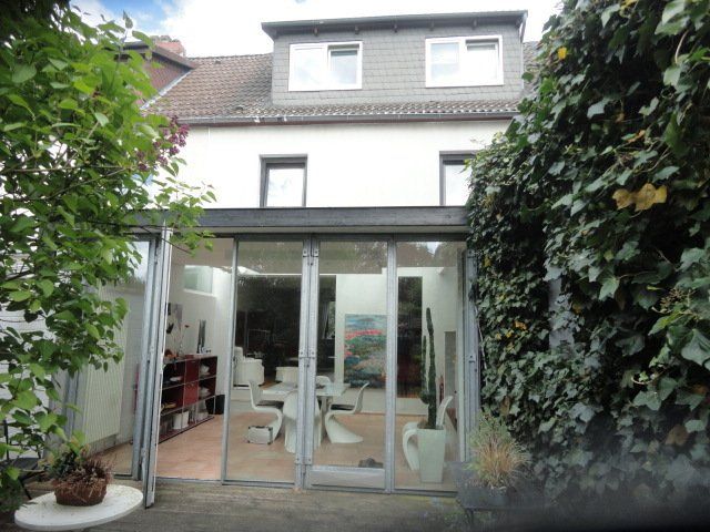 Die Rückseite eines Hauses mit einer großen Glastür