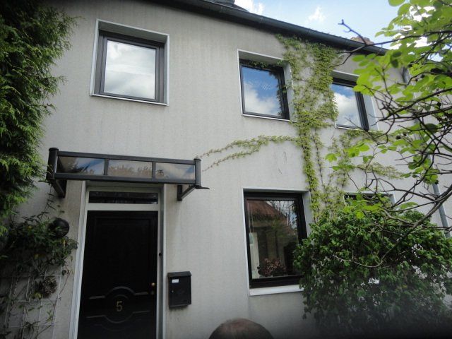 Ein weißes Haus mit einer schwarzen Tür und schwarzen Fenstern