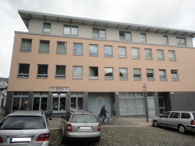 Ein Mann fährt Fahrrad vor einem großen Gebäude