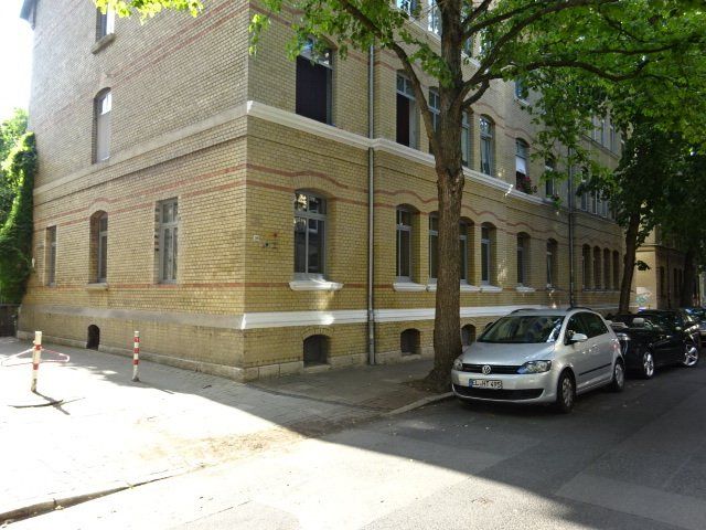 Ein silbernes Auto steht vor einem Backsteingebäude