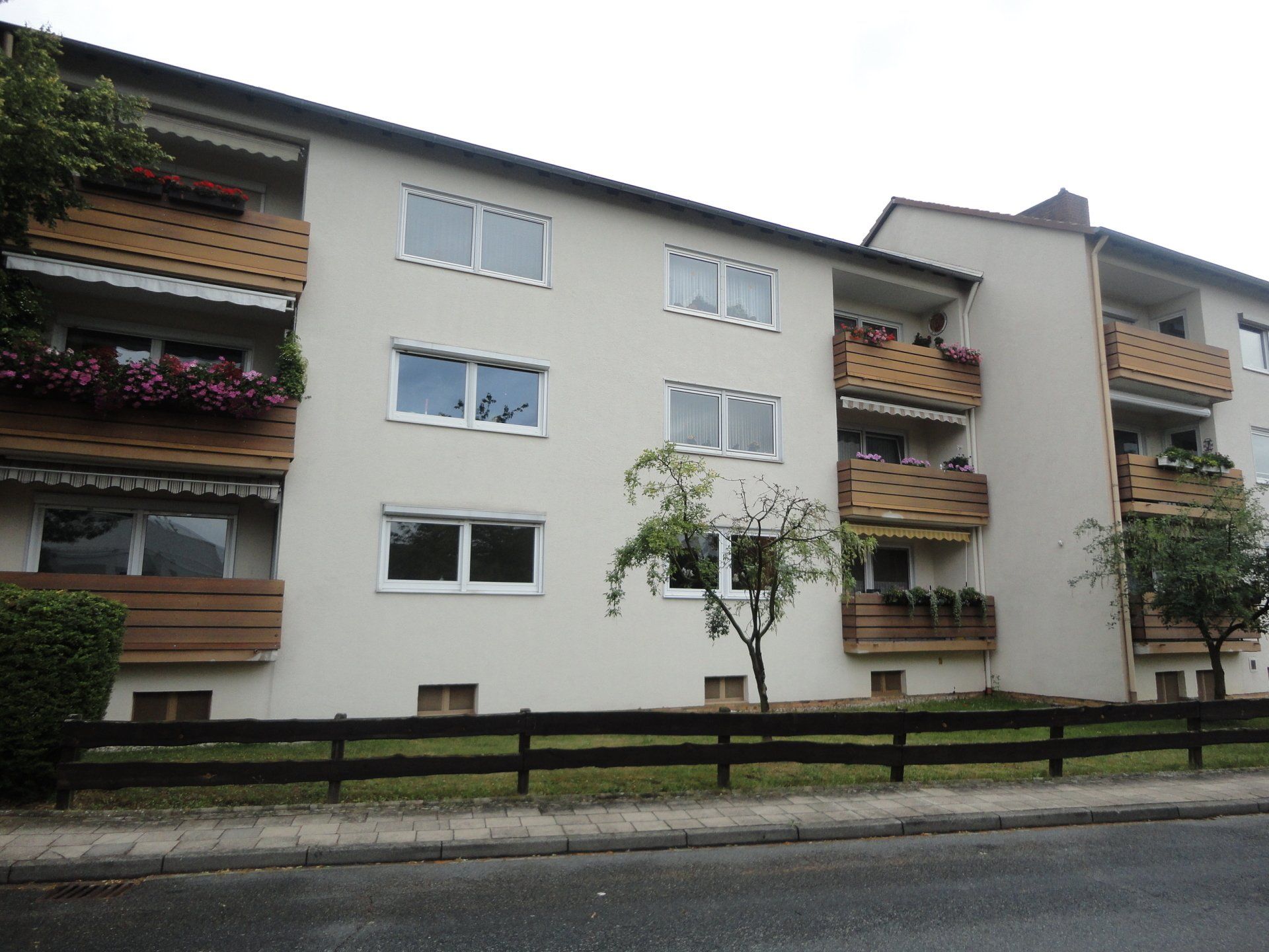 Ein großes Mehrfamilienhaus mit einem Holzzaun davor