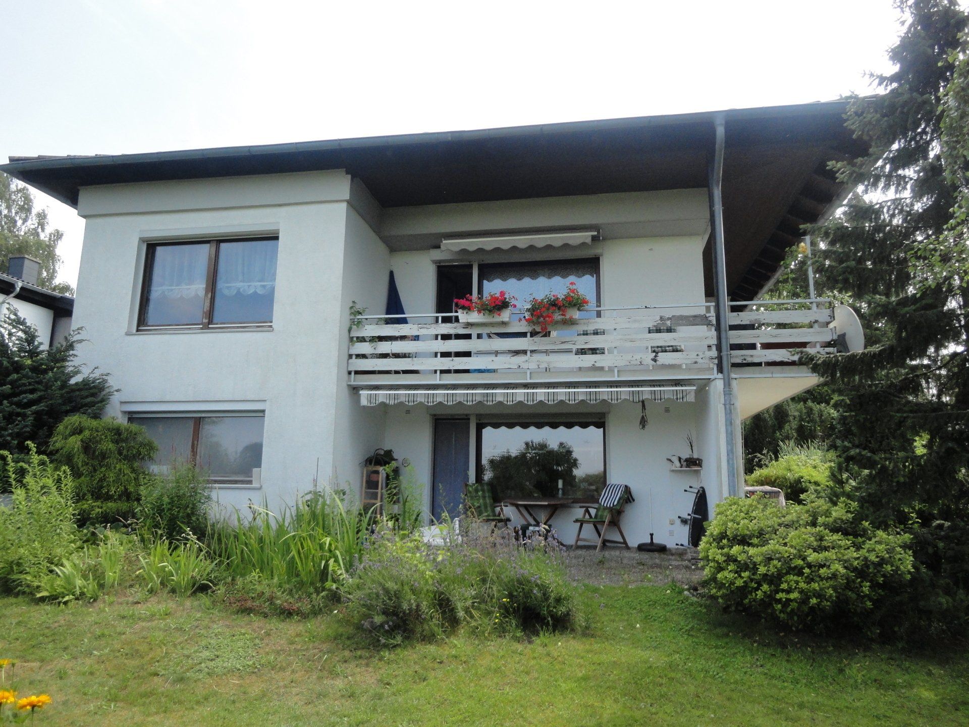 Ein großes weißes Haus mit einem Balkon im zweiten Stock