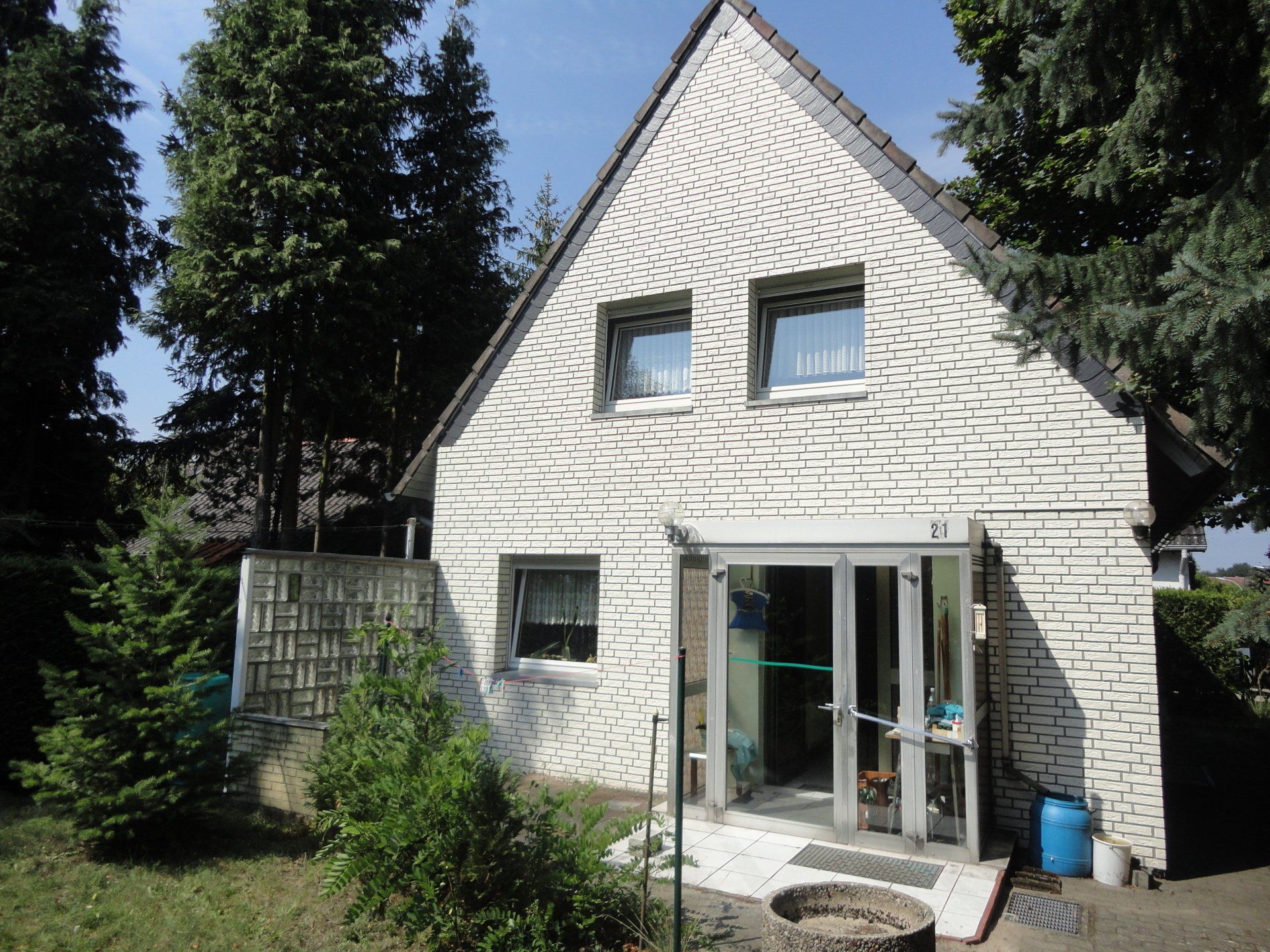 Ein weißes Backsteinhaus mit einem dreieckigen Dach