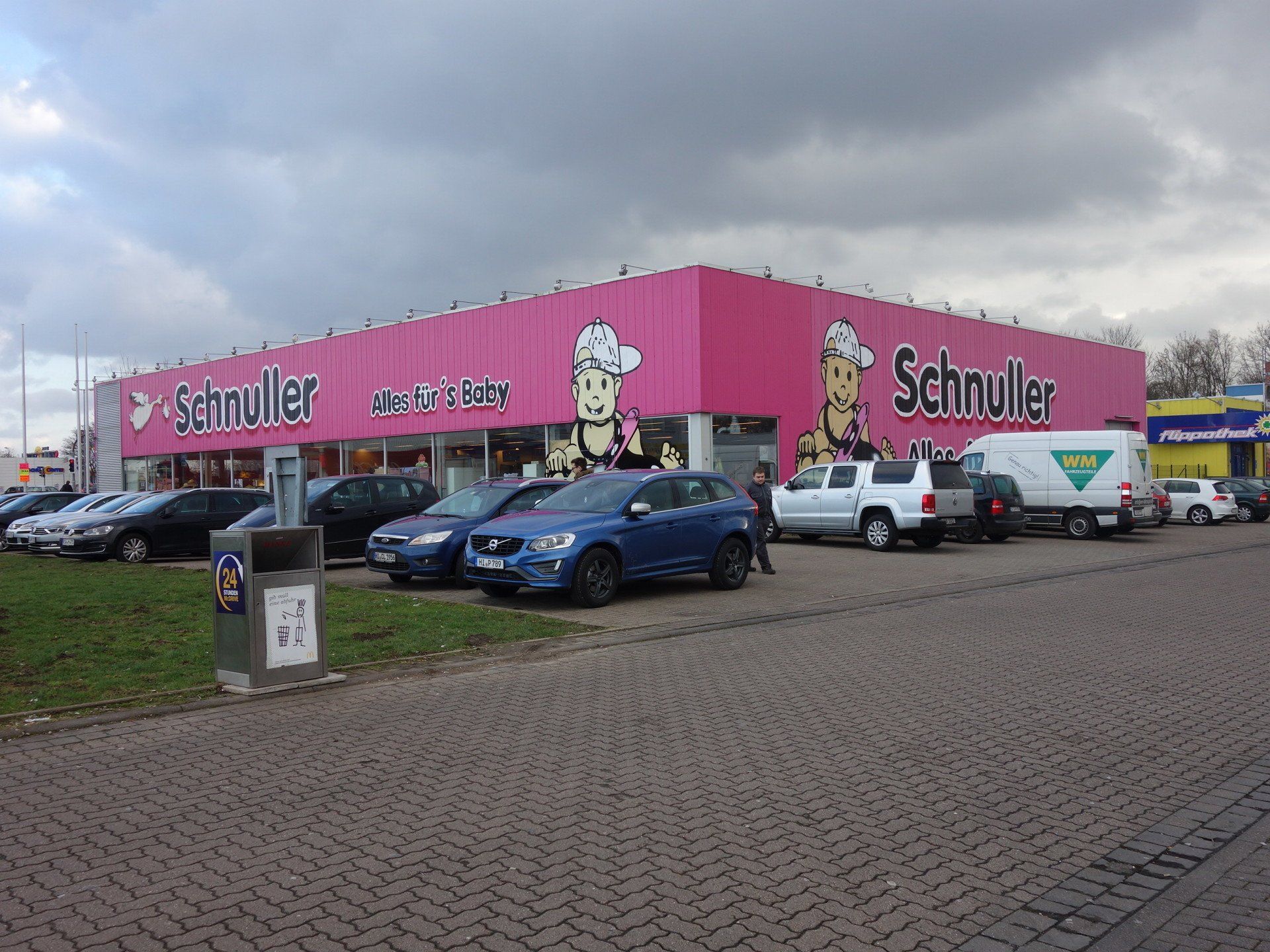 Ein rosafarbenes Gebäude mit davor geparkten Autos.