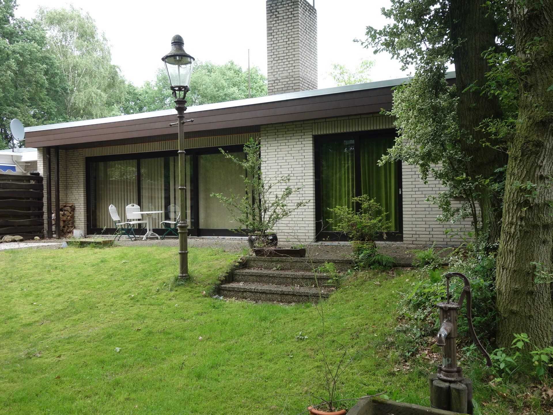 Ein weißes Backsteinhaus mit einem großen Rasen davor