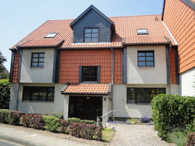 Ein großes weißes Haus mit einem roten Ziegeldach