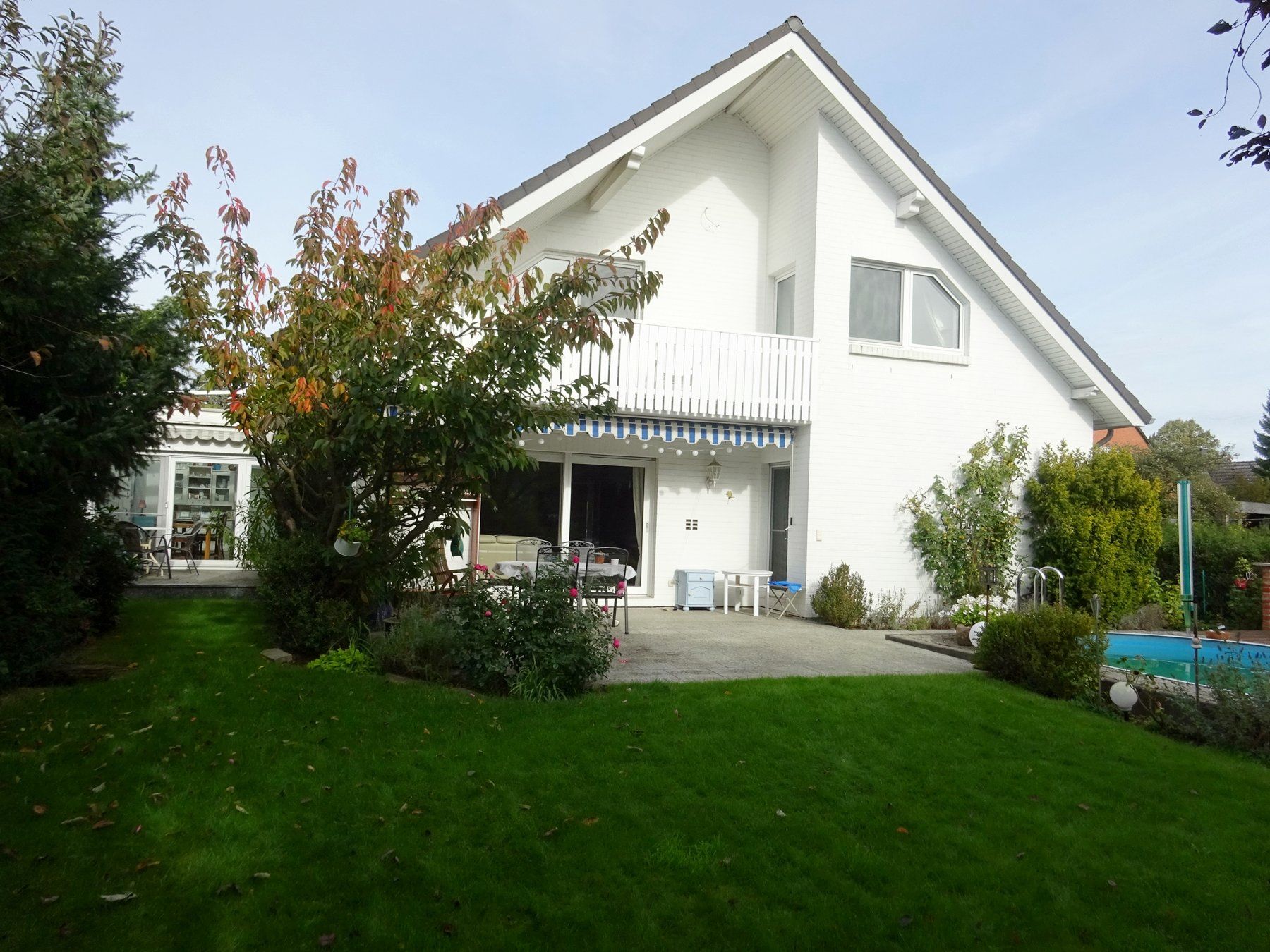 Ein großes weißes Haus mit einem Swimmingpool im Hinterhof